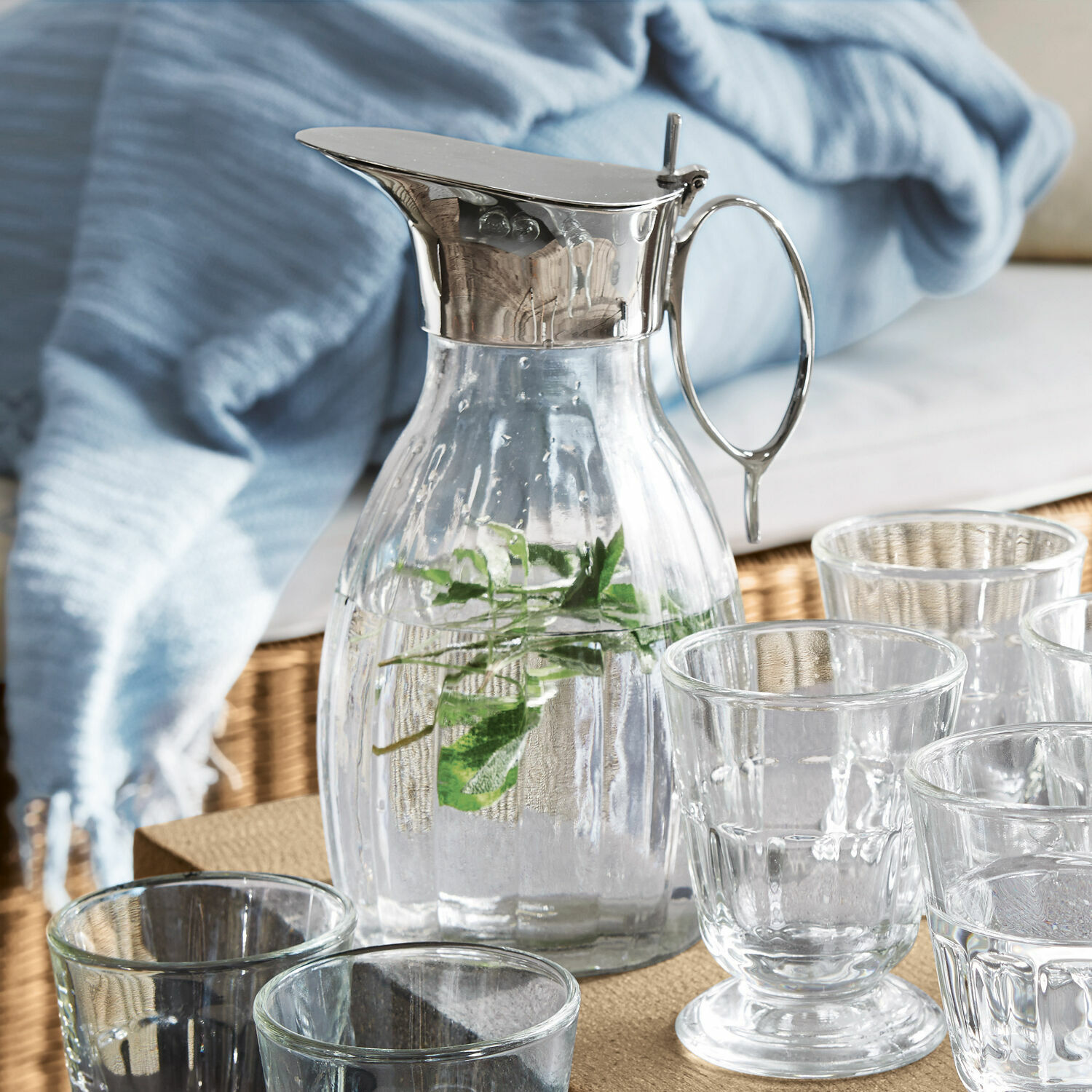 Caraffa Agudelle Caraffa in vetro con coperchio e manico in metallo, acqua con erbe, bicchieri sul tavolo