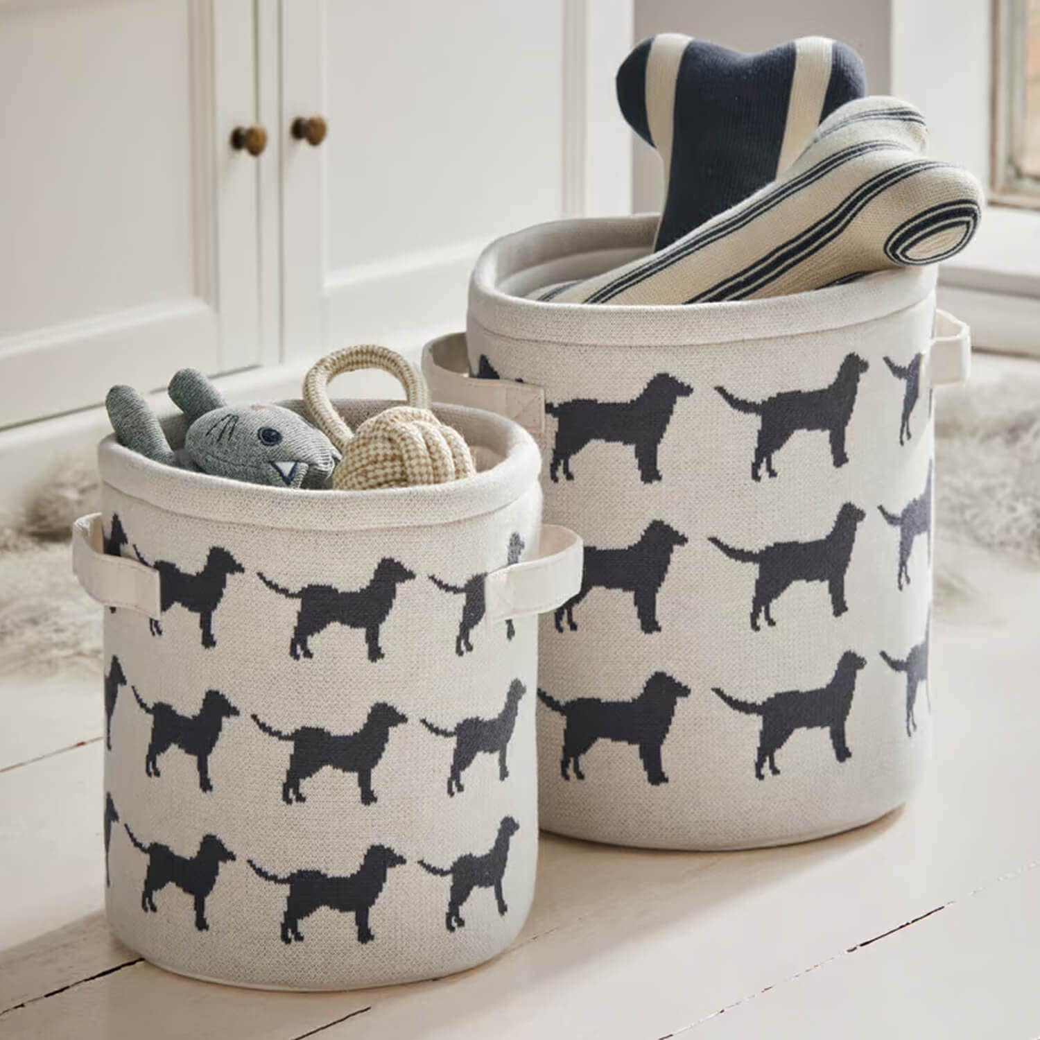 Cesti in cotone beige con motivo cane nero, perfetti per riporre giocattoli e accessori.