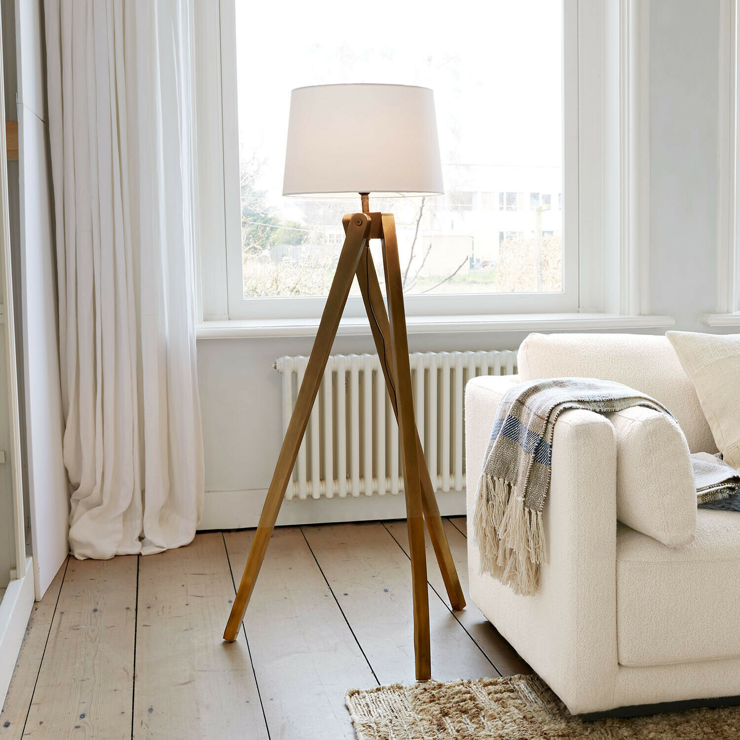 Lampada a stelo Kelvio Lampada da terra con base in legno e paralume bianco in soggiorno luminoso con divano beige
