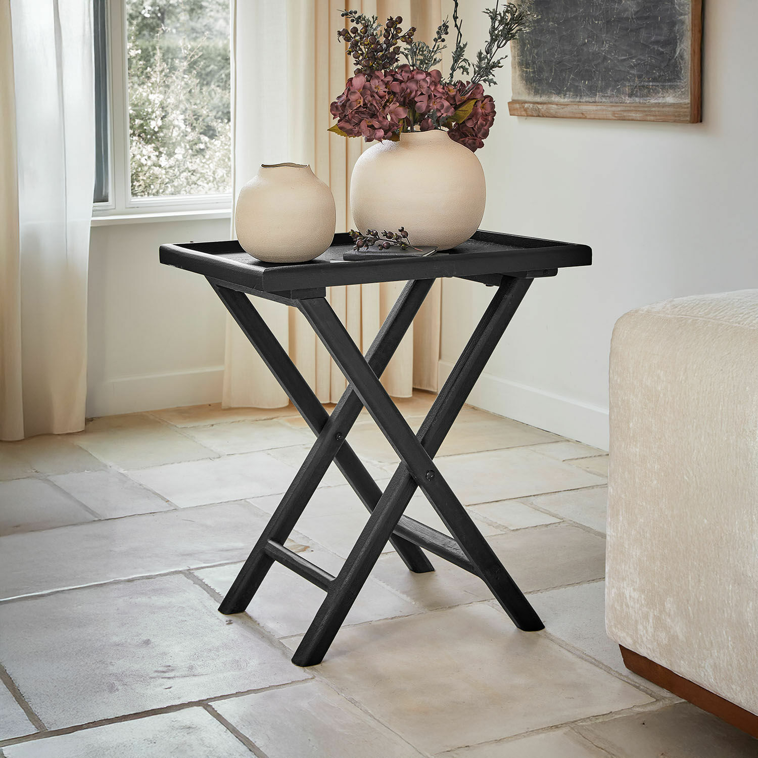 Tavolino di complemento Paventino Tavolino pieghevole nero in legno con due vasi beige e decorazione floreale in soggiorno luminoso