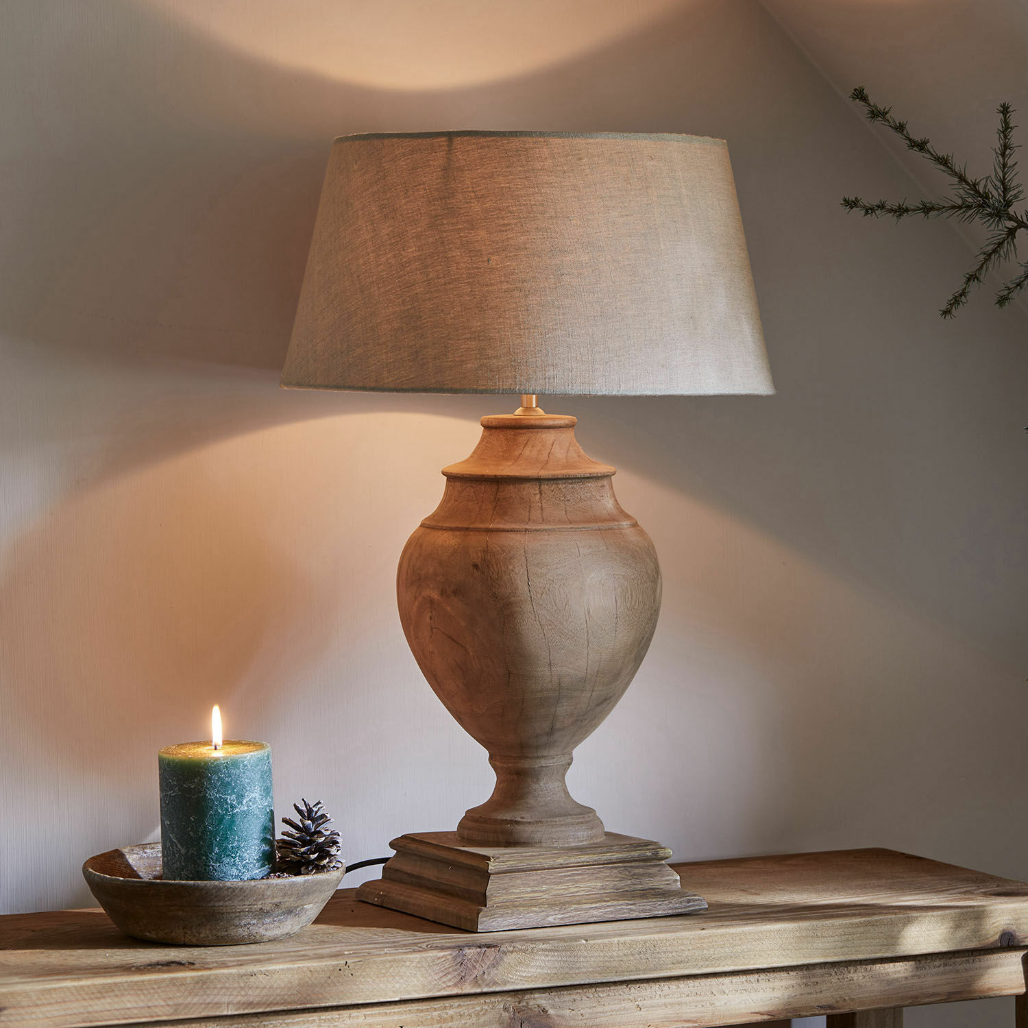 Lampada da tavolo Sauverny Lampada da tavolo con base in legno e paralume beige su tavolo in legno, candela decorativa accanto