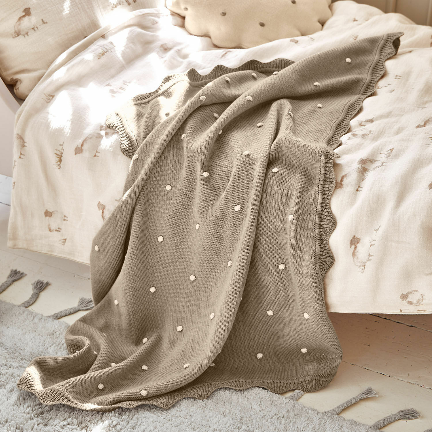Plaid Saphie Coperta beige lavorata a maglia con pois bianchi su letto chiaro, soffice e decorativa