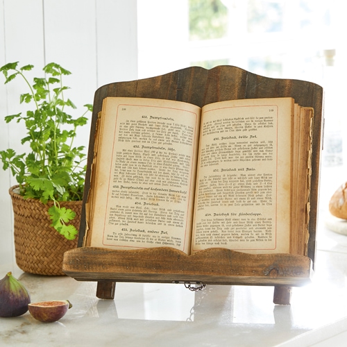 Porta libri da cucina in legno colore naturale su piano chiaro con pianta e fichi