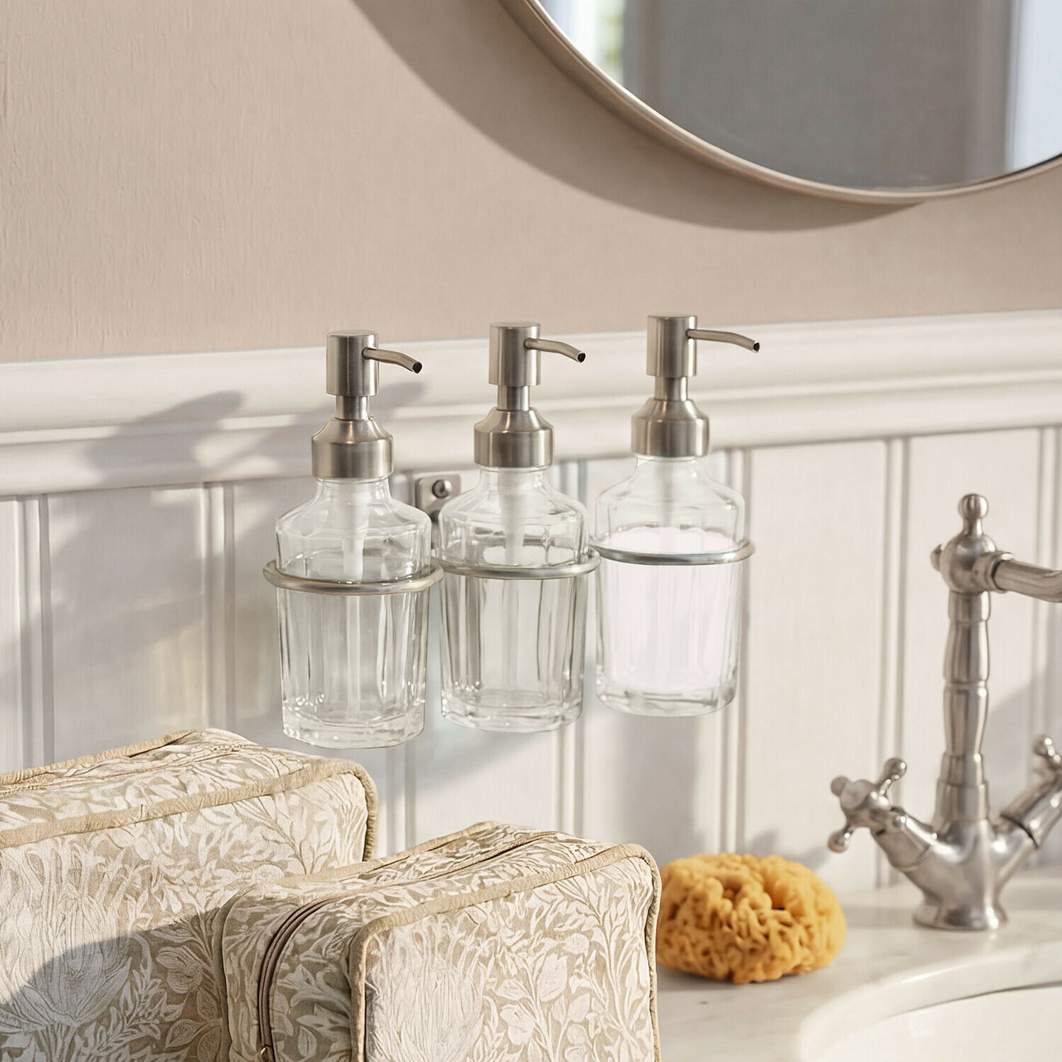 Dispenser per sapone Virellane Tre dispenser di sapone in vetro con pompe metalliche accanto al lavabo e specchio in bagno