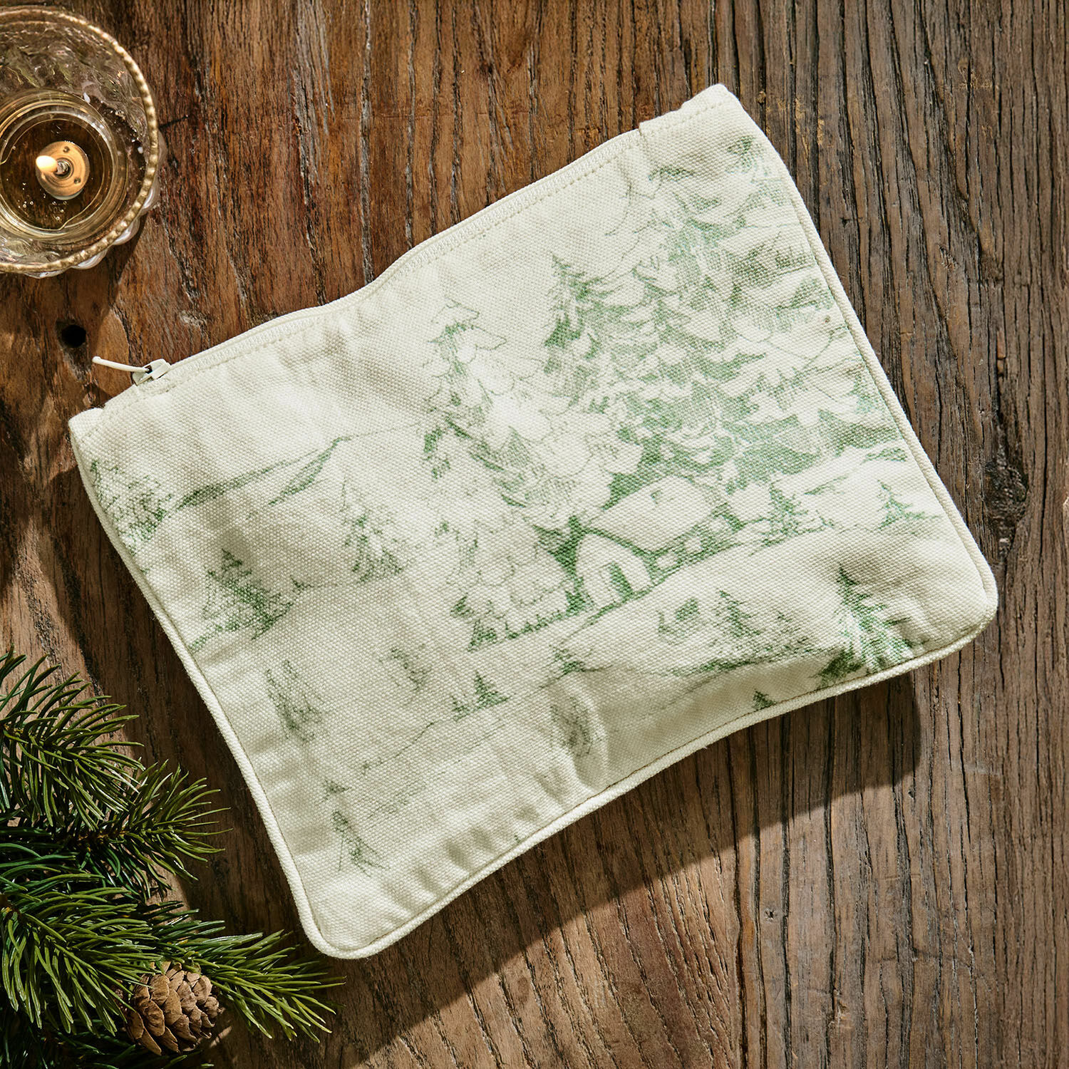 Borsa piccola Norathia Astuccio beige in cotone con stampa verde di paesaggio boschivo su tavolo in legno