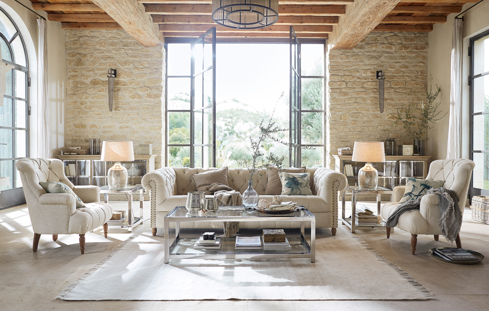Soggiorno classico elegante con divano beige, poltrone, tavolino in vetro e materiali naturali