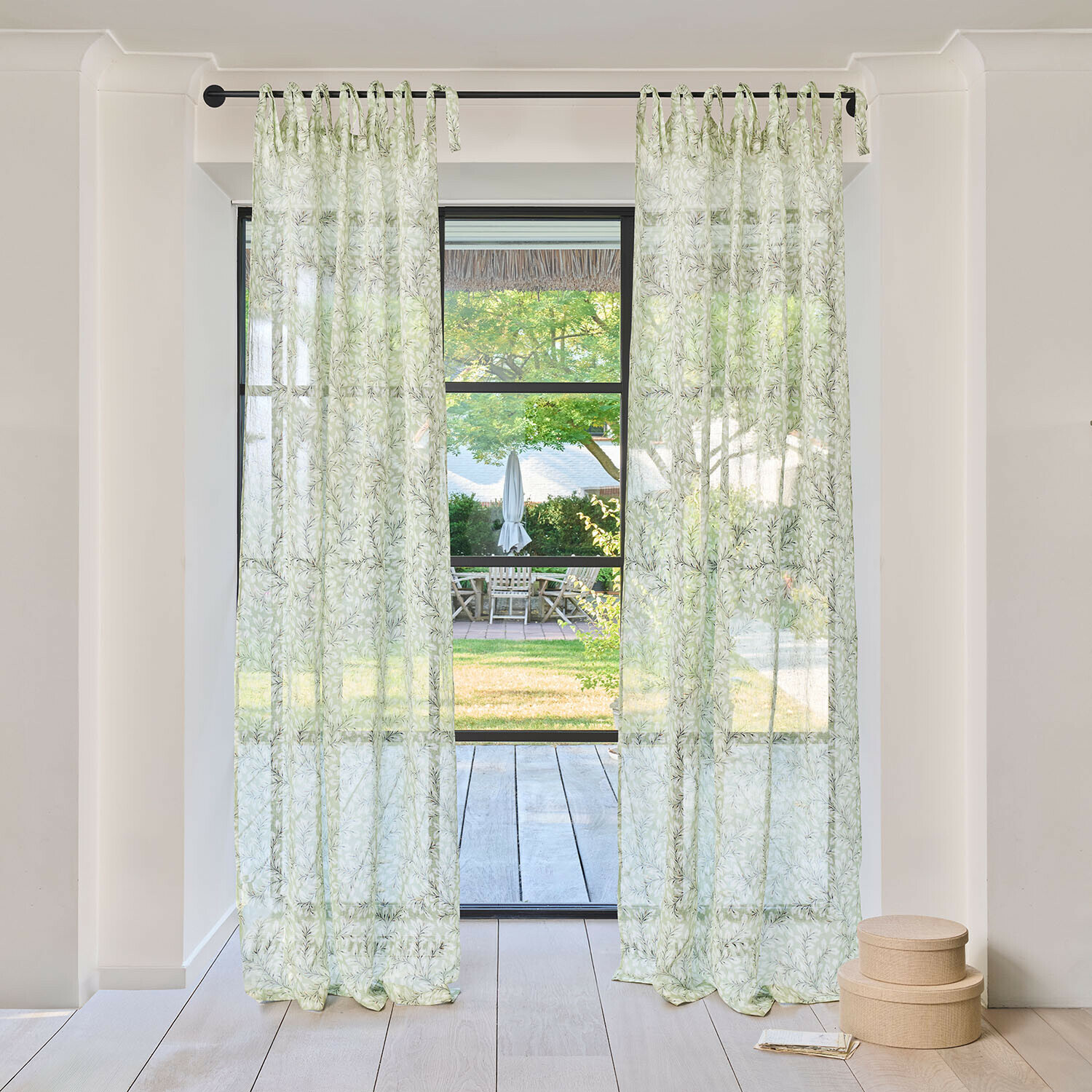 Tenda Norelline Tende trasparenti con motivo foglie verdi su bastone nero in stanza luminosa con vista sul giardino