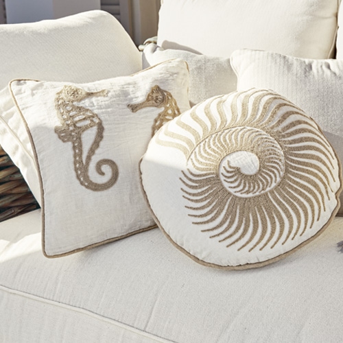 Cuscini decorativi in cotone crema con motivo cavalluccio marino e conchiglia su divano chiaro
