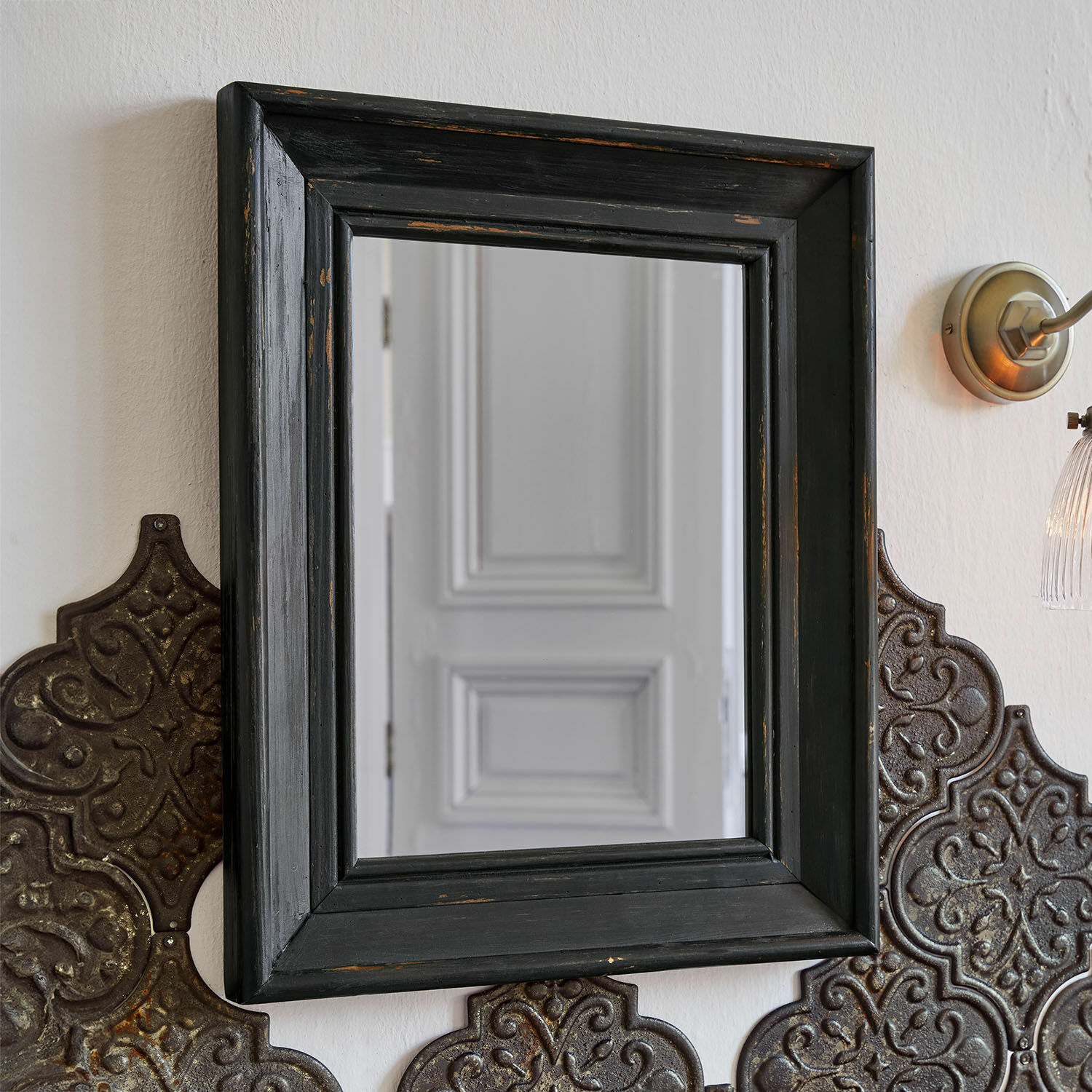 Specchio Orlise Specchio quadrato con cornice in legno nero invecchiato su parete con pannelli metallici decorativi