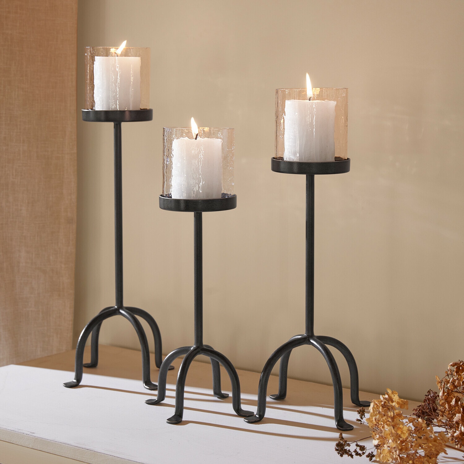 Set di 3 portalumini Tanbira Set di tre portacandele in metallo nero con candele bianche e coperture in vetro strutturato