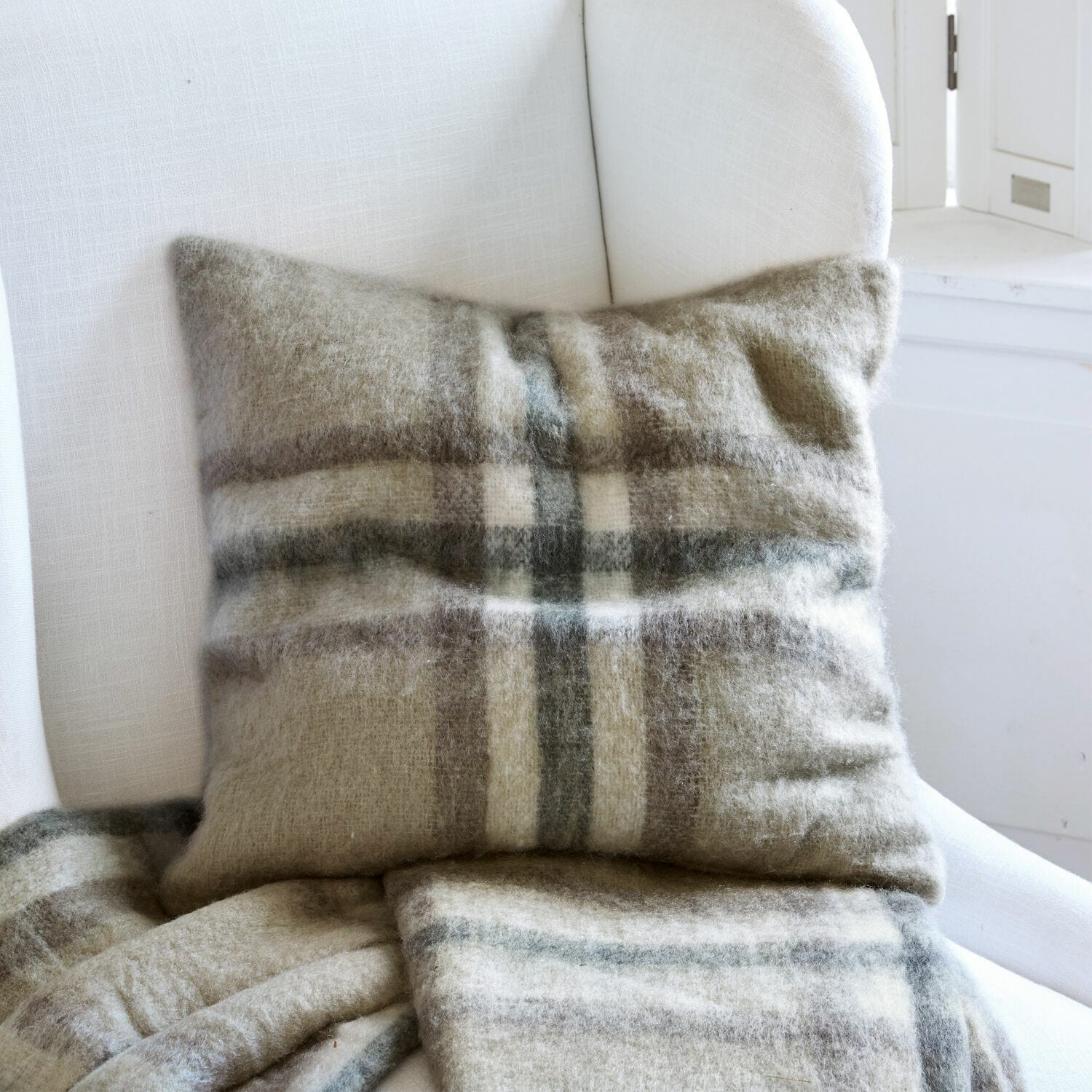 Copricuscini Argoub Cuscino e coperta in lana a quadri beige e grigi su poltrona bianca