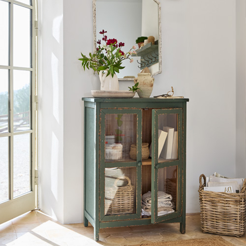 Mobile verde in legno con ante in vetro stile vintage per riporre oggetti in soggiorno