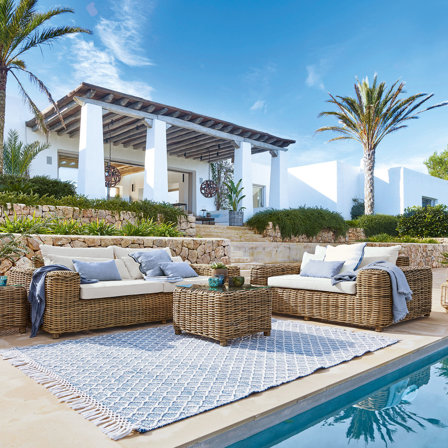Salottino Camas Set di mobili da giardino in rattan naturale con cuscini crema vicino alla piscina