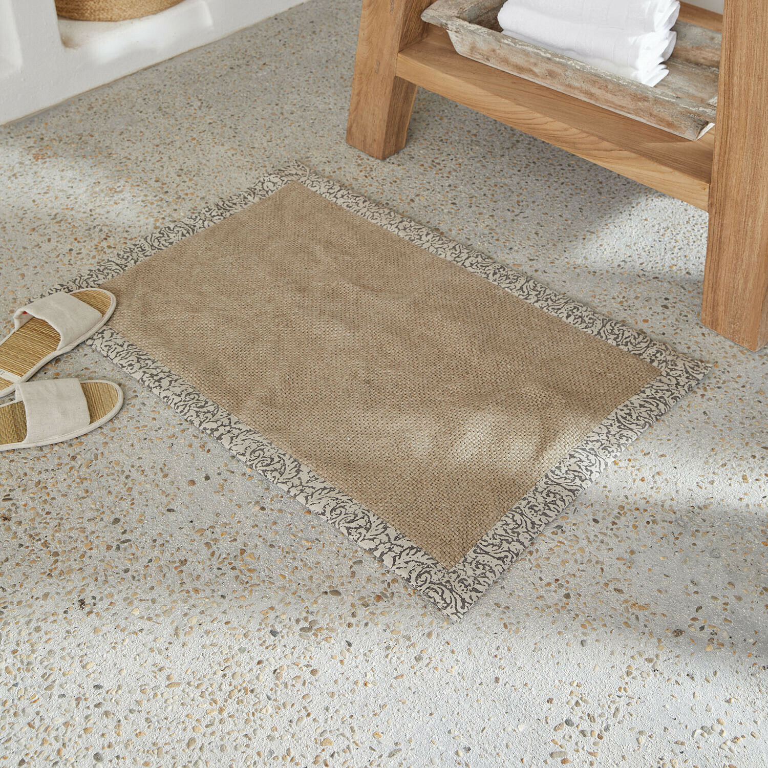 Scendibagno Falmont Tappetino beige in materiale naturale con bordo grigio decorativo su pavimento chiaro in pietra
