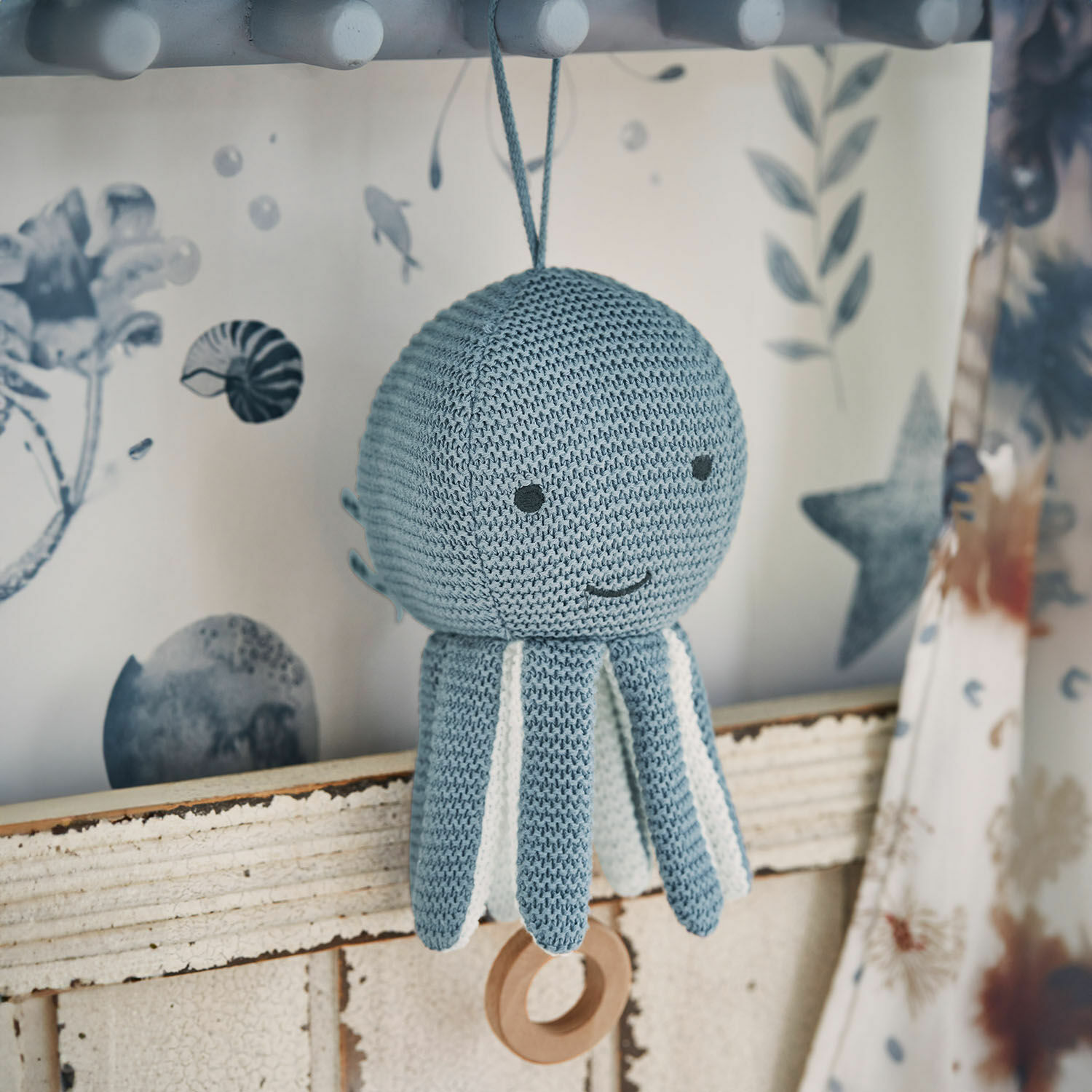 Carillon Cozycot Giocattolo polpo lavorato a maglia blu con dettagli bianchi e anello di legno appeso, decorazione morbida