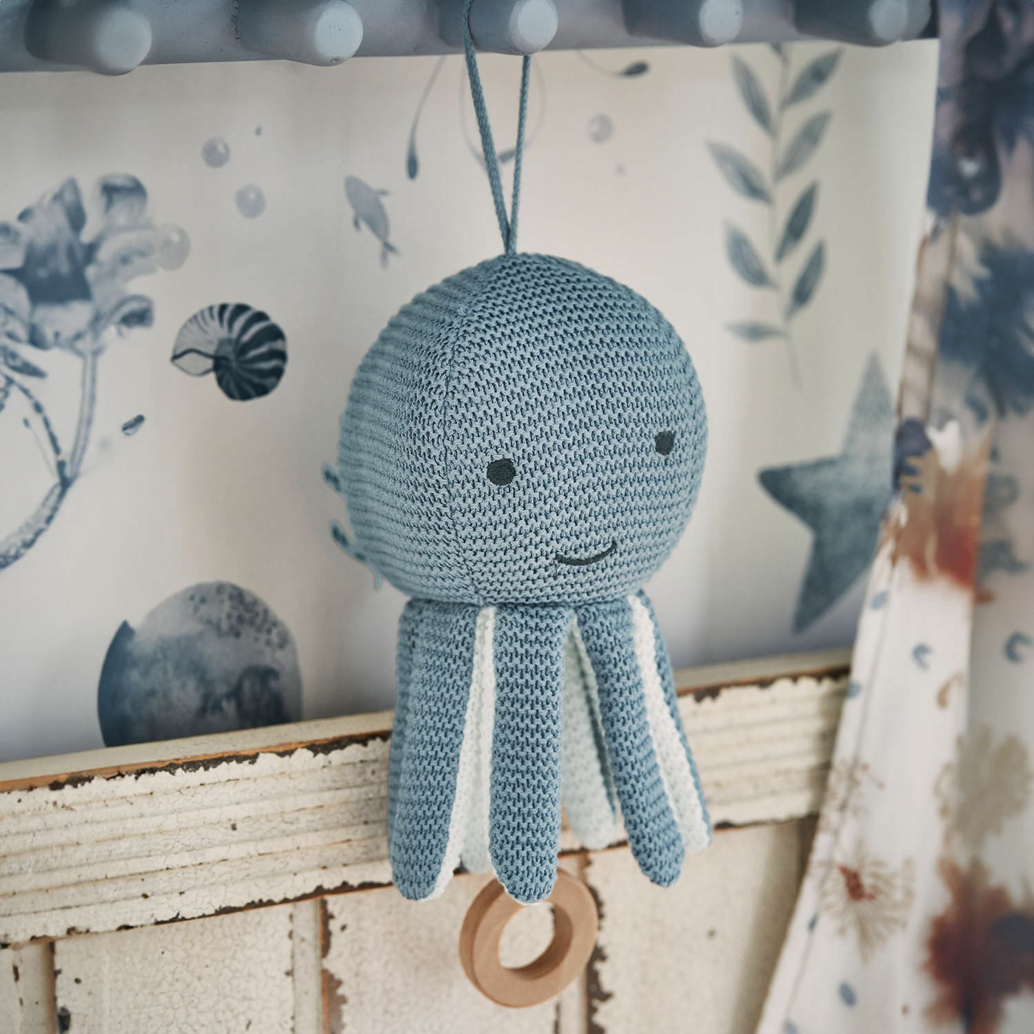 Carillon Cozycot Giocattolo polpo lavorato a maglia blu con dettagli bianchi e anello di legno appeso, decorazione morbida