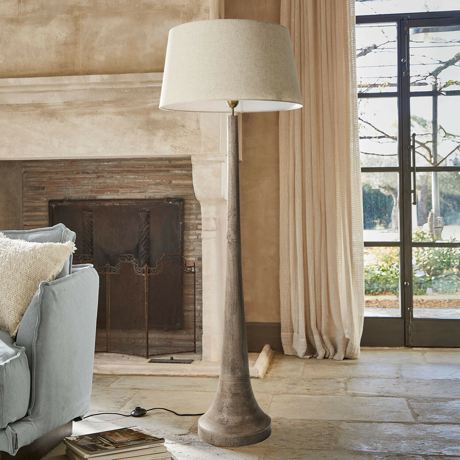 Lampada a stelo Helsfjord Lampada da terra con base in legno e paralume beige in soggiorno accogliente con camino