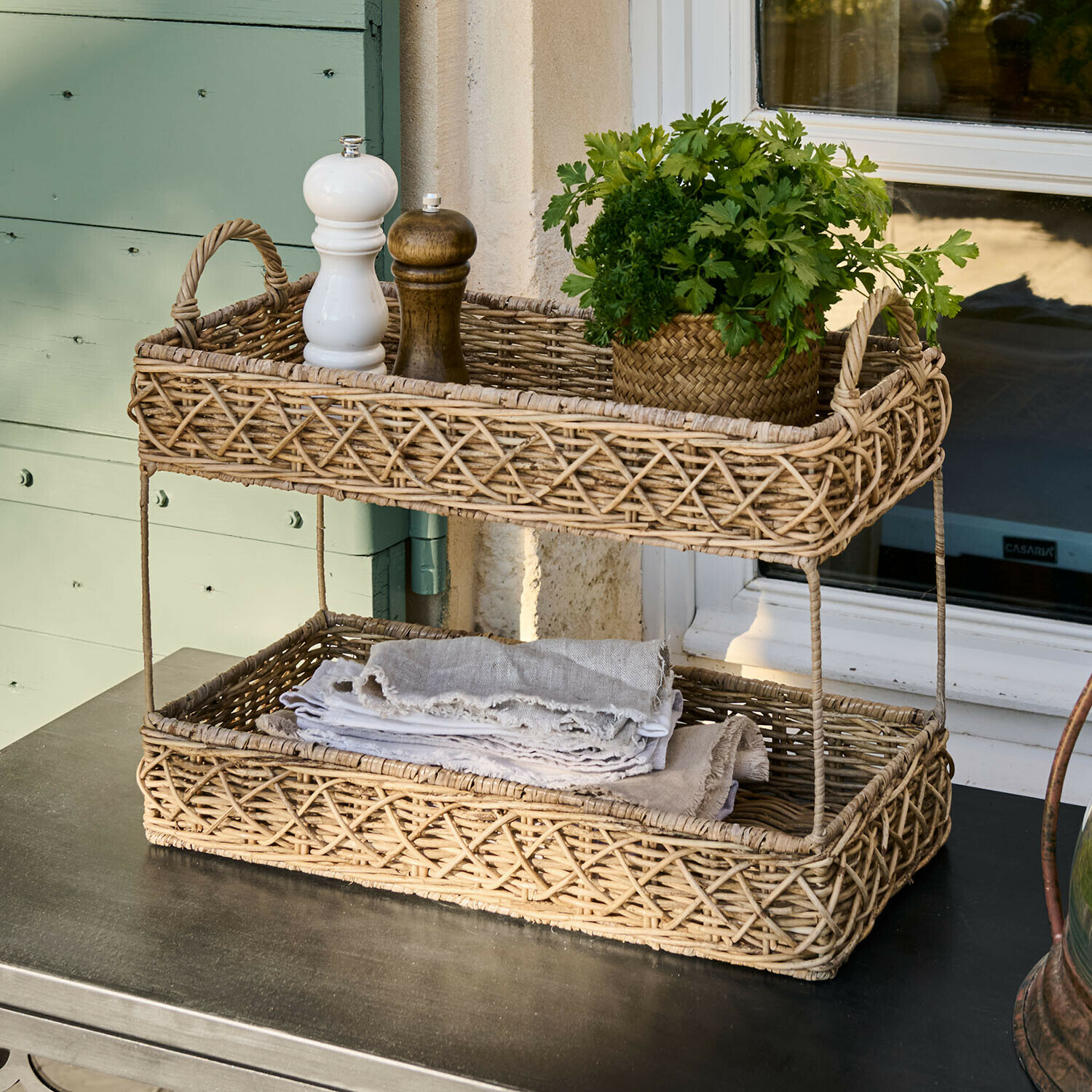 Cesto a due livelli in rattan naturale con spezie e erbe fresche su tavolo