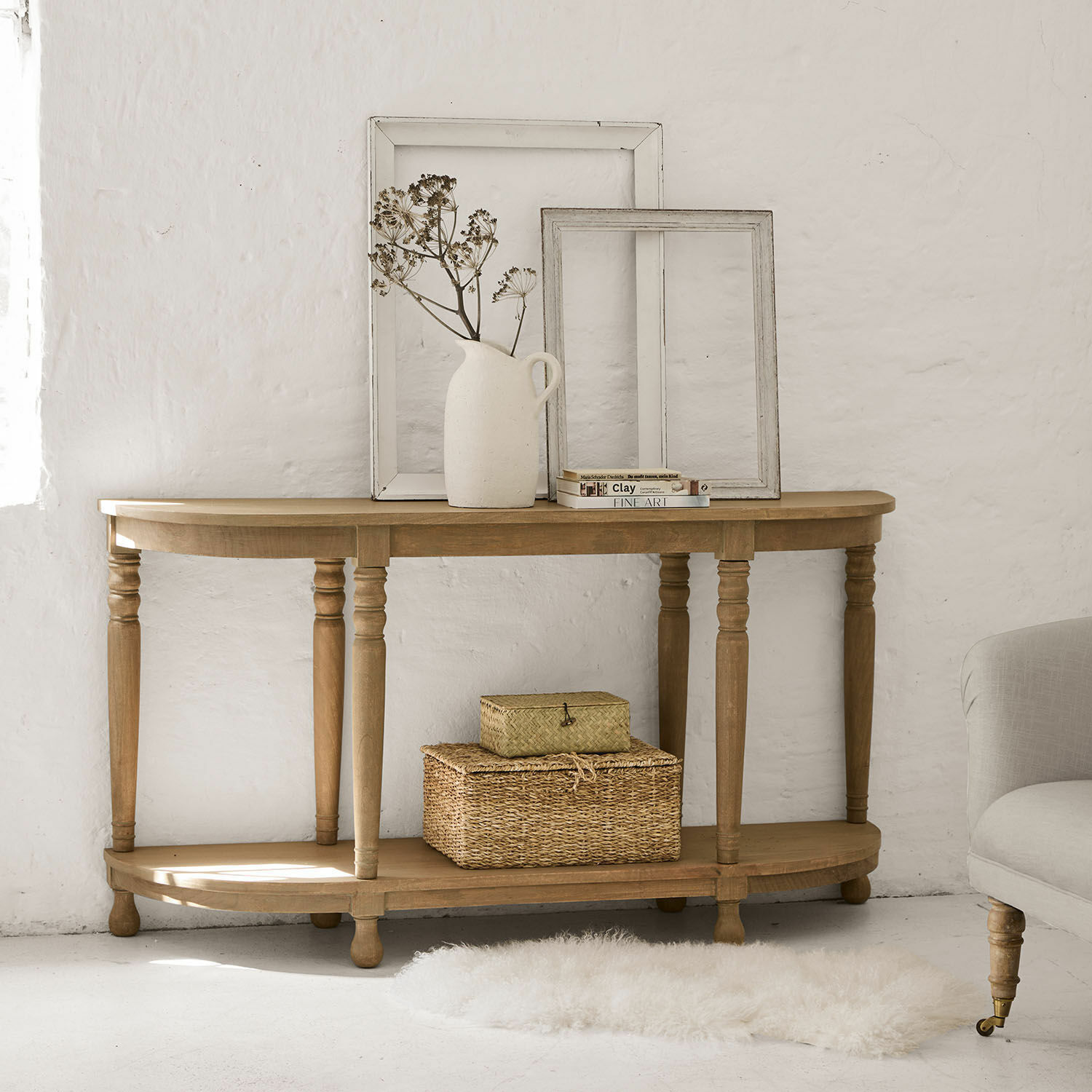 Consolle Brookdale Consolle in legno naturale con cornici decorative e vaso con fiori secchi in interno luminoso