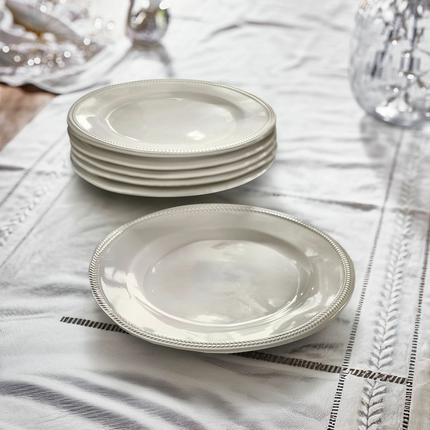 Set di 6 piattini Norrvik Set di piatti bianchi in ceramica con bordo decorativo su tovaglia di lino per sala da pranzo