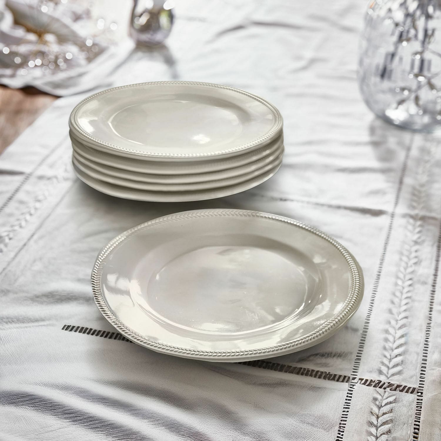 Set di 6 piattini Norrvik Set di piatti bianchi in ceramica con bordo decorativo su tovaglia di lino per sala da pranzo