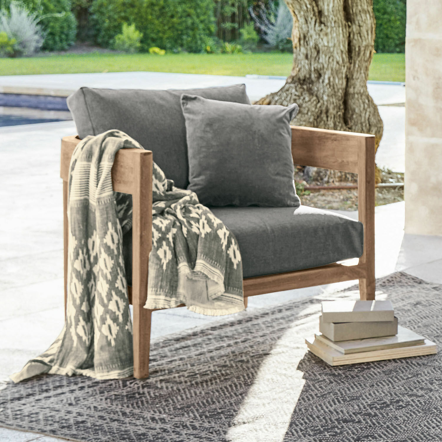 Poltrona Courtelevant Poltrona con struttura in legno e cuscini grigi, decorata con coperta a motivi all'aperto