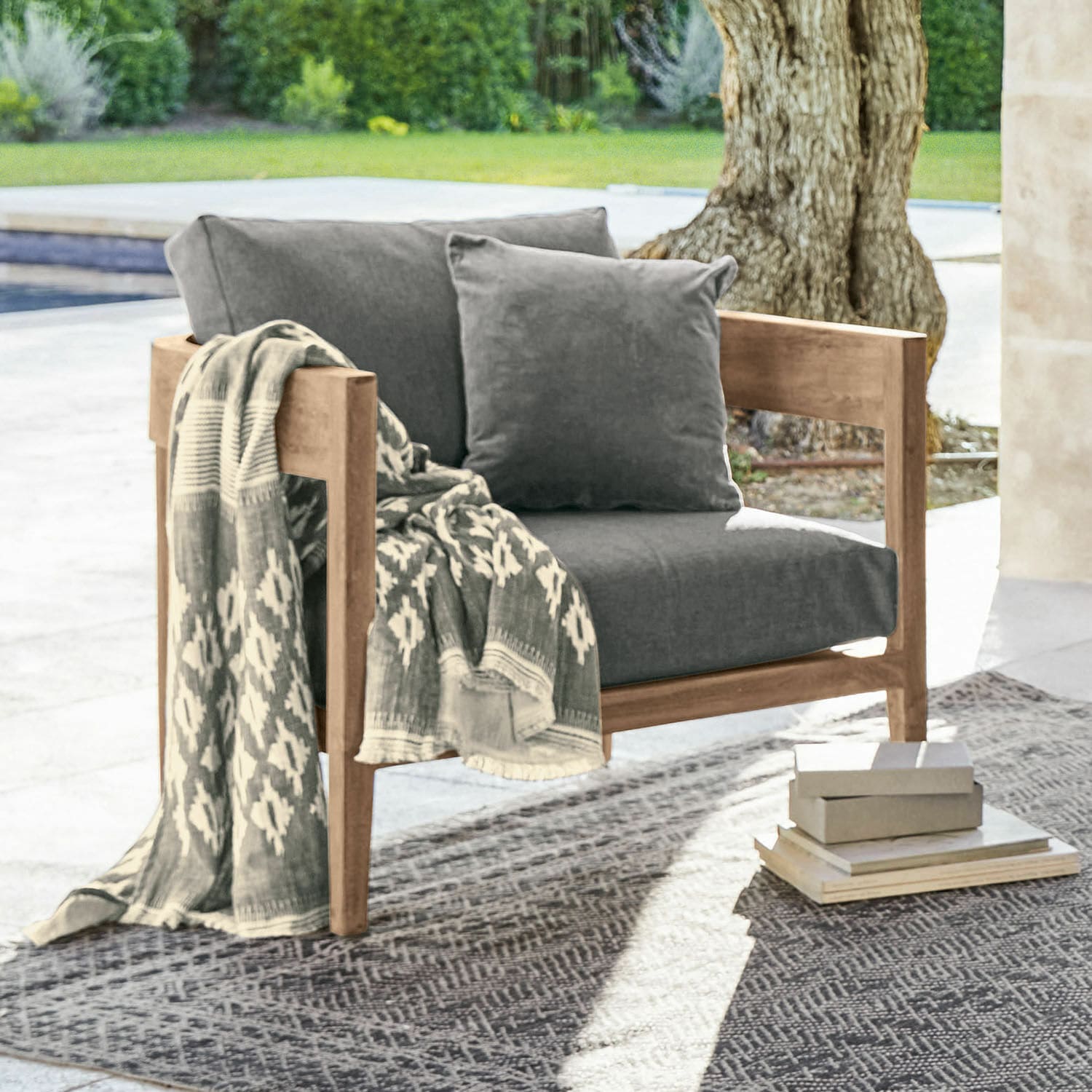 Poltrona Courtelevant Poltrona con struttura in legno e cuscini grigi, decorata con coperta a motivi all'aperto