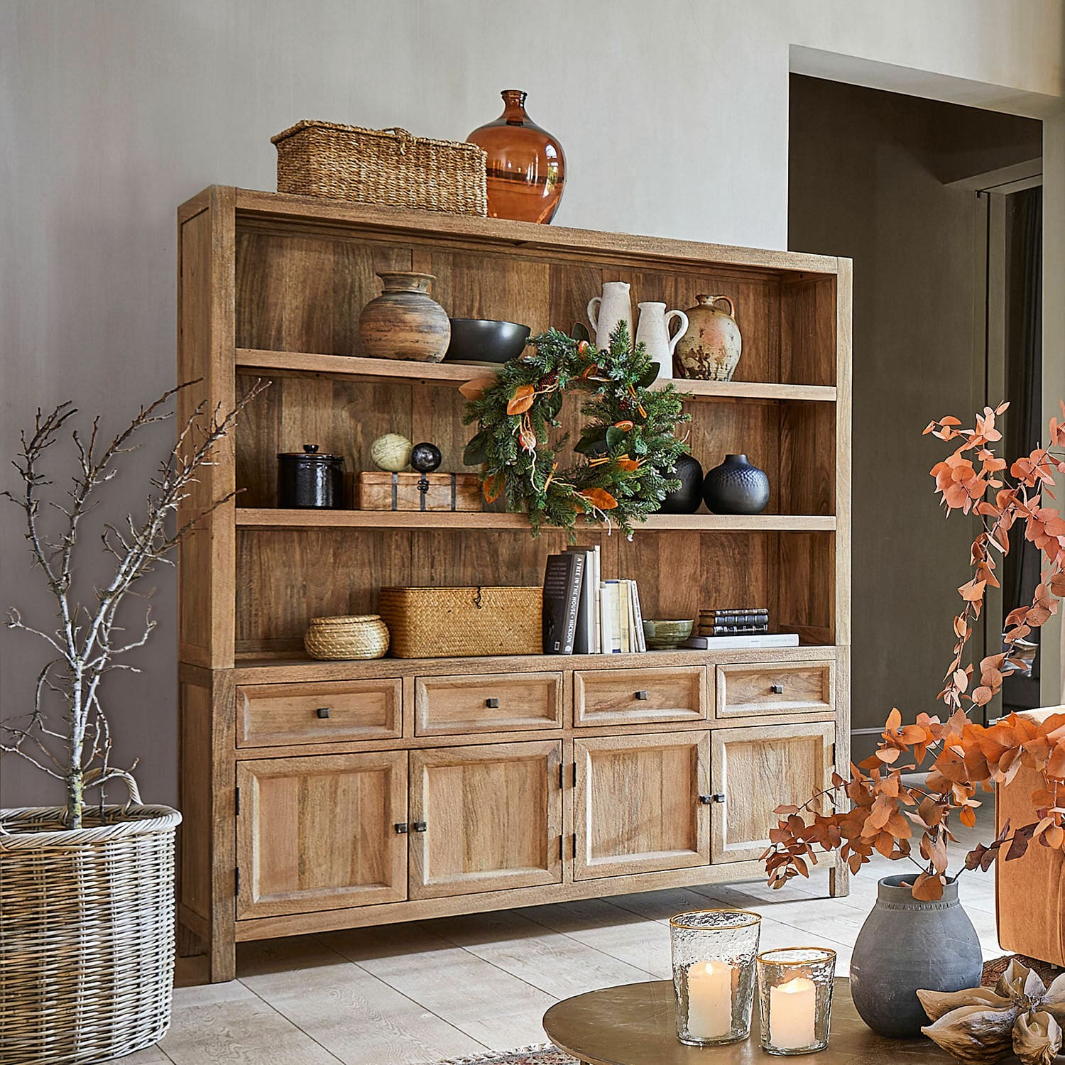 Credenza New Bedford Credenza in legno naturale con ripiani e cassetti decorata con vasi, libri e candele in soggiorno