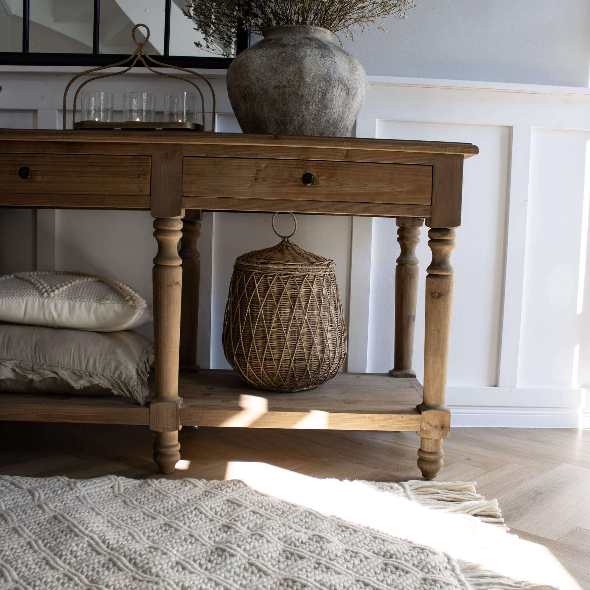 Tappeto beige a trama grossa con frange su pavimento in legno chiaro in ambiente luminoso