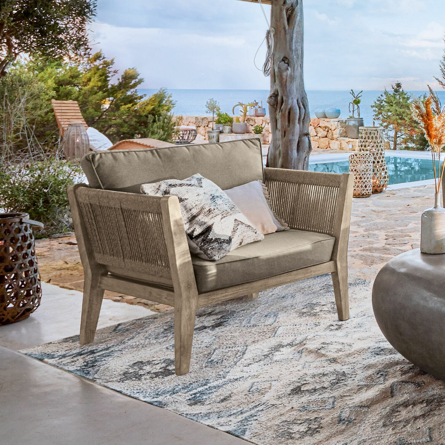 Poltrona 100% FSC® Biarritz Divano da esterno in legno e tessuto beige su terrazza con vista mare