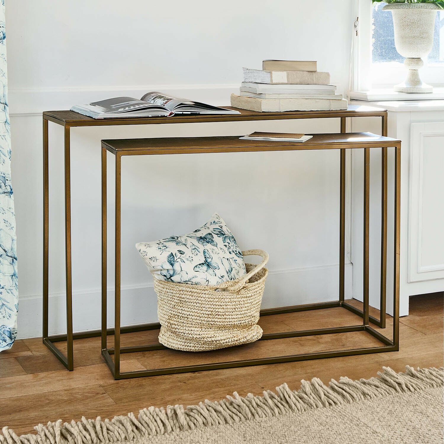 Coppia di consolle Olvenzo Set di due tavolini in metallo color ottone con libri decorativi e cesta con cuscino