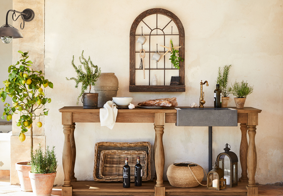 Tavolo in legno con lavello in cemento e rubinetto in rame stile mediterraneo con piante e decorazioni