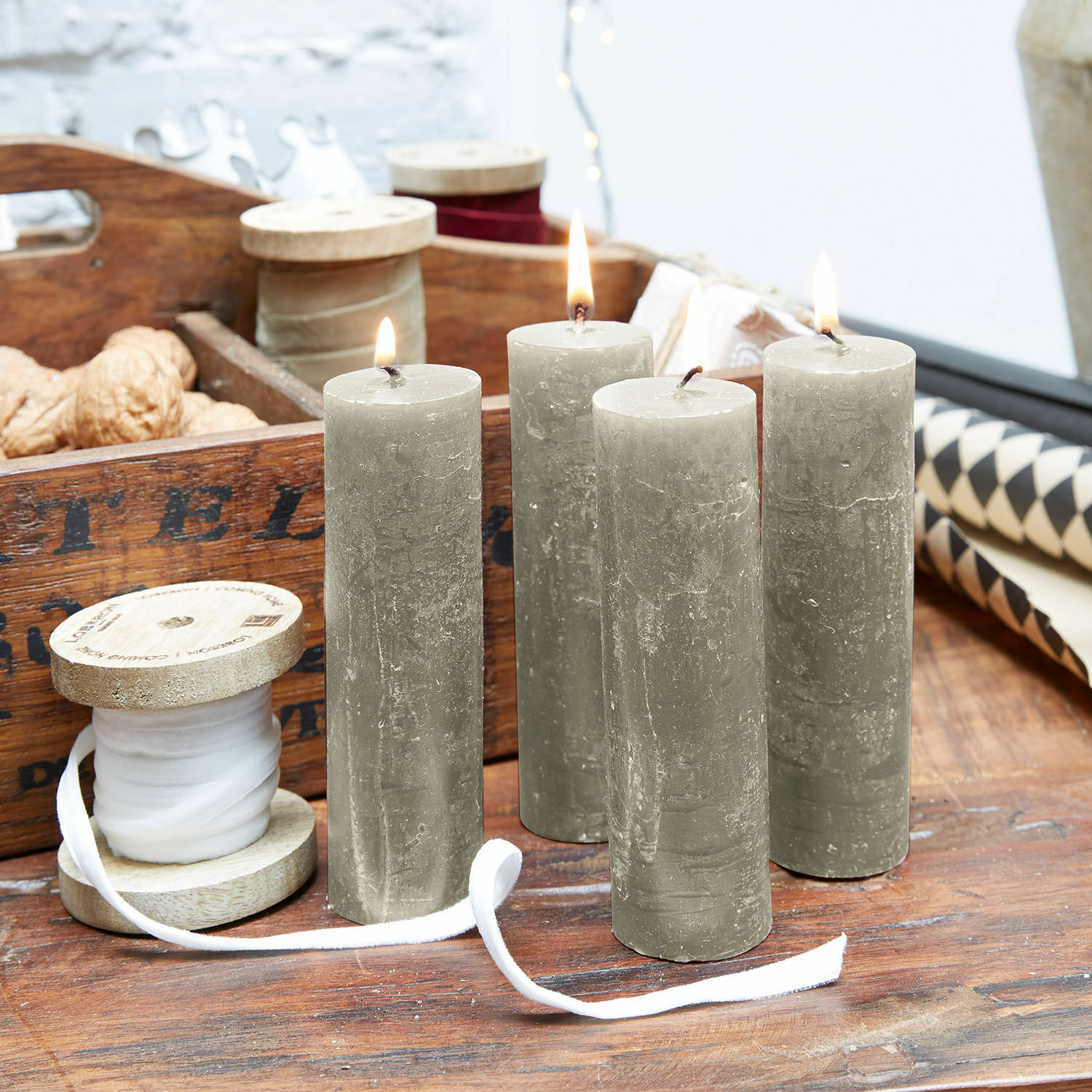 Set di 4 candele Muriel Quattro candele cilindriche grigie su tavolo in legno con bobina di legno e decorazioni