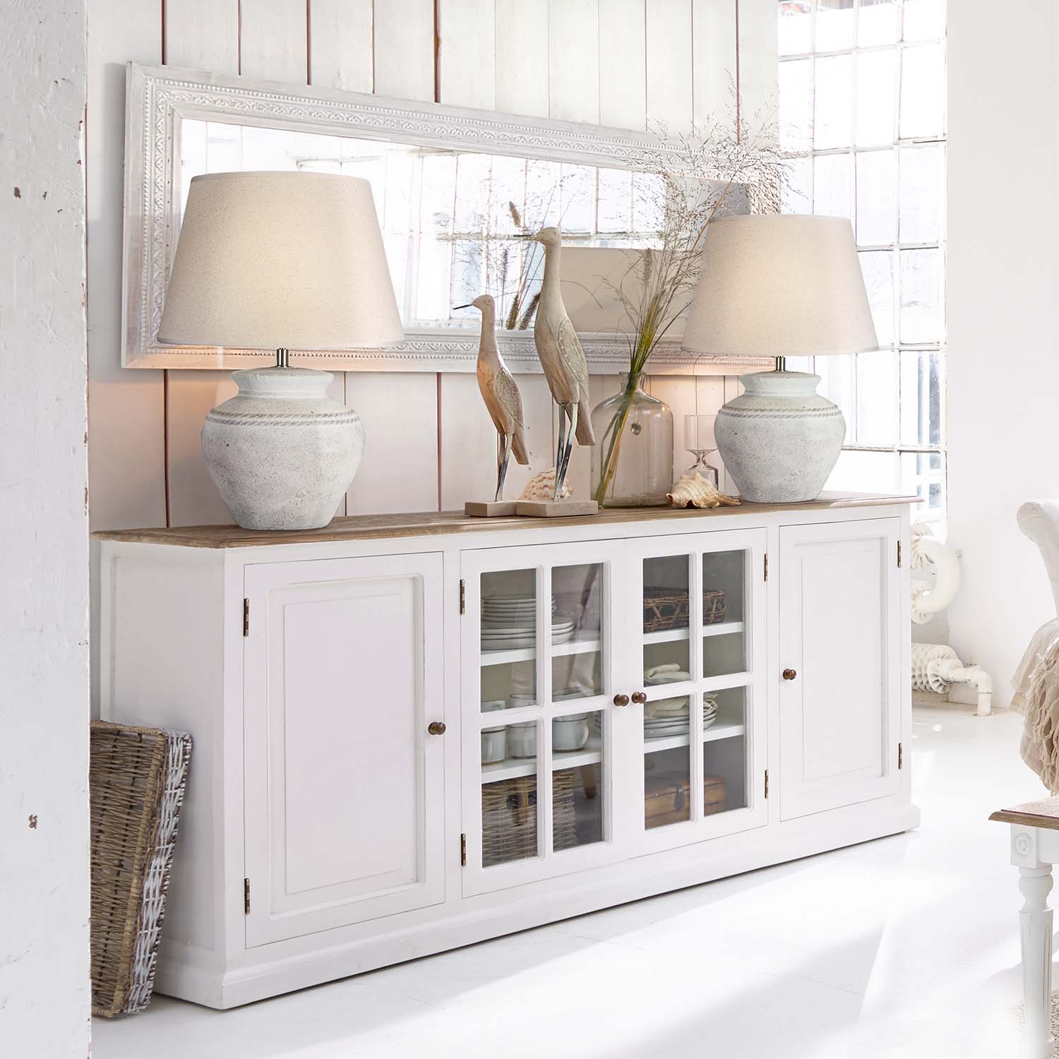Credenza in legno bianco con ante in vetro e lampade in ceramica in interno luminoso