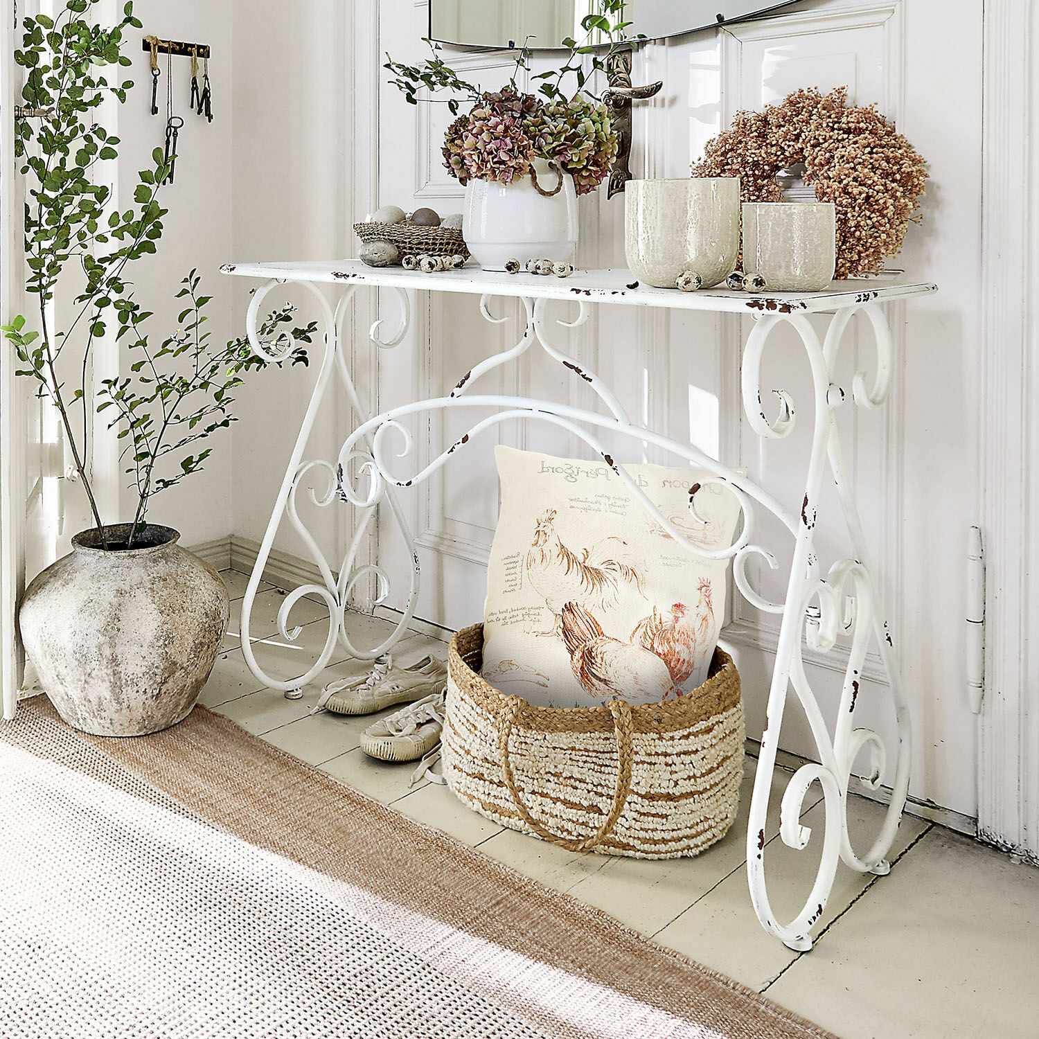 Consolle Stonem Tavolo in metallo bianco con piante decorative e cesta di vimini con cuscino in stile rustico