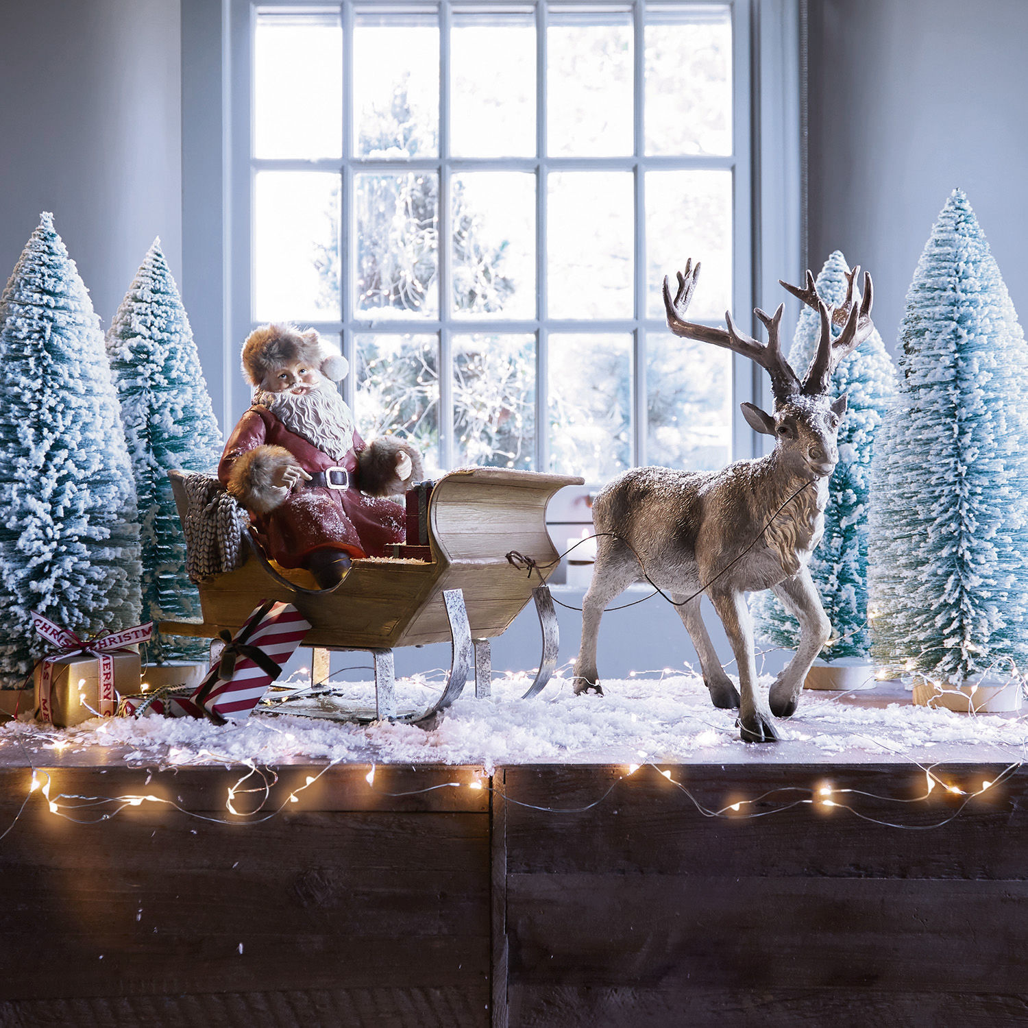 Slitta di Babbo Natale Palaima Figura di Babbo Natale con mantello rosso su slitta in legno con renna e alberi innevati decorativi