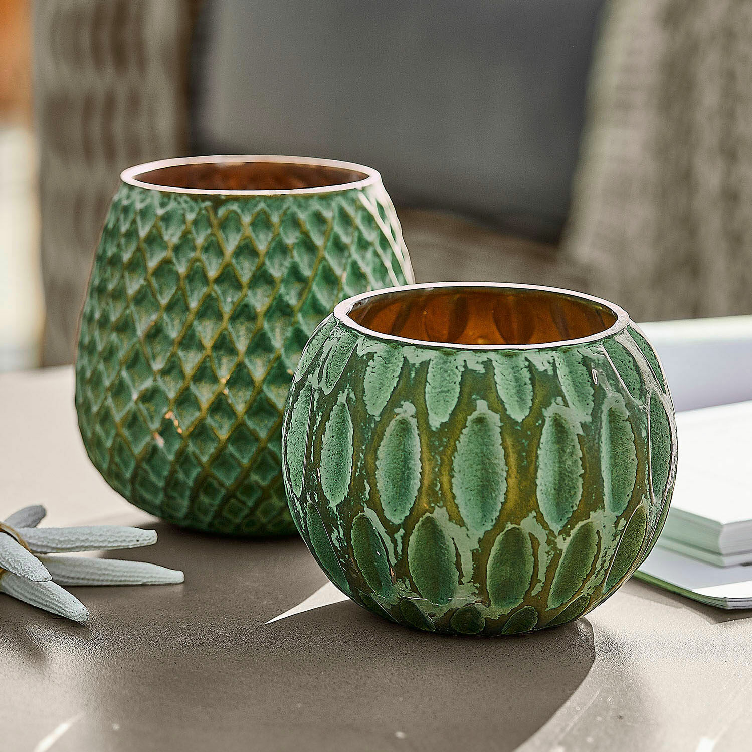 Coppia di portacandele Xerice Set di due portacandele in ceramica verde con texture e interno dorato su tavolo