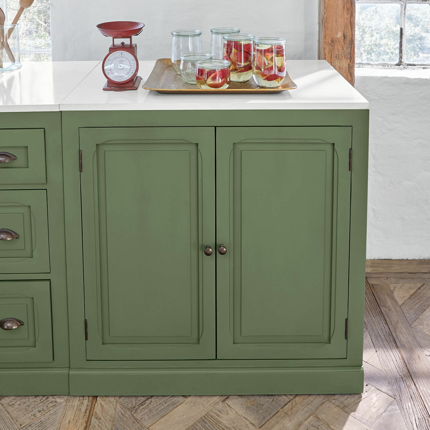 Mobile per la cucina Lansbury Credenza verde in legno con piano bianco e bilancia da cucina rossa in metallo sopra