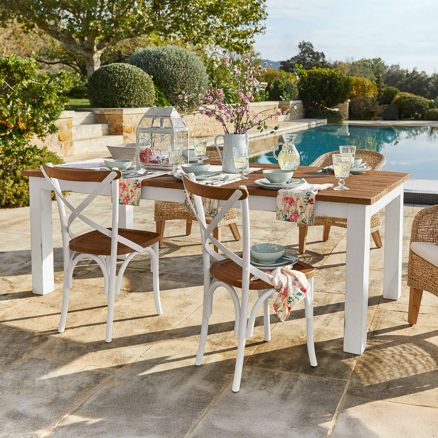 Tavolo Kirkdale Tavolo da giardino in legno con gambe bianche e sedie rustiche vicino alla piscina