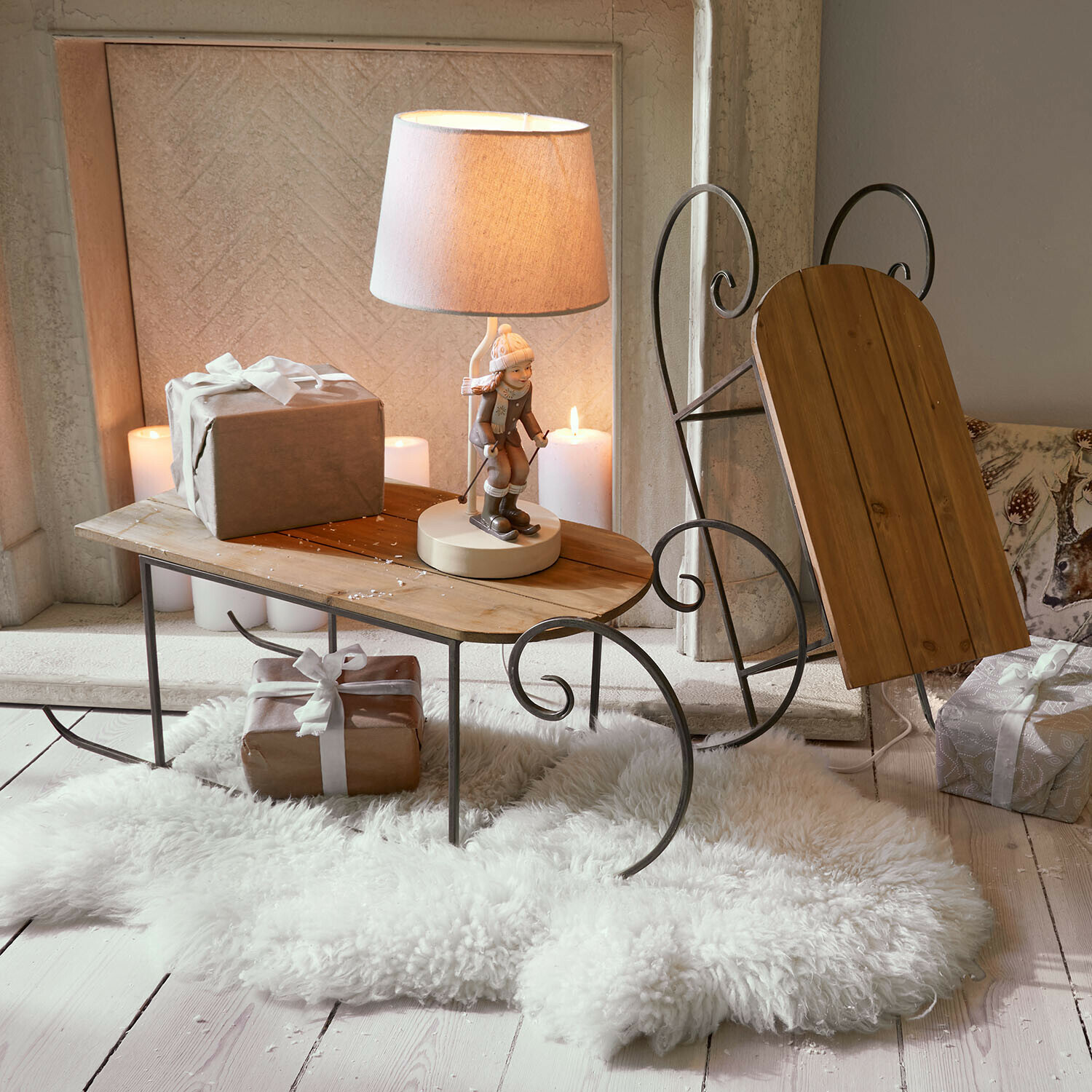 Set di 2 slitte decorative Skalara Tavolino a forma di slitta in legno e metallo con lampada e regali su tappeto bianco in pelliccia sintetica