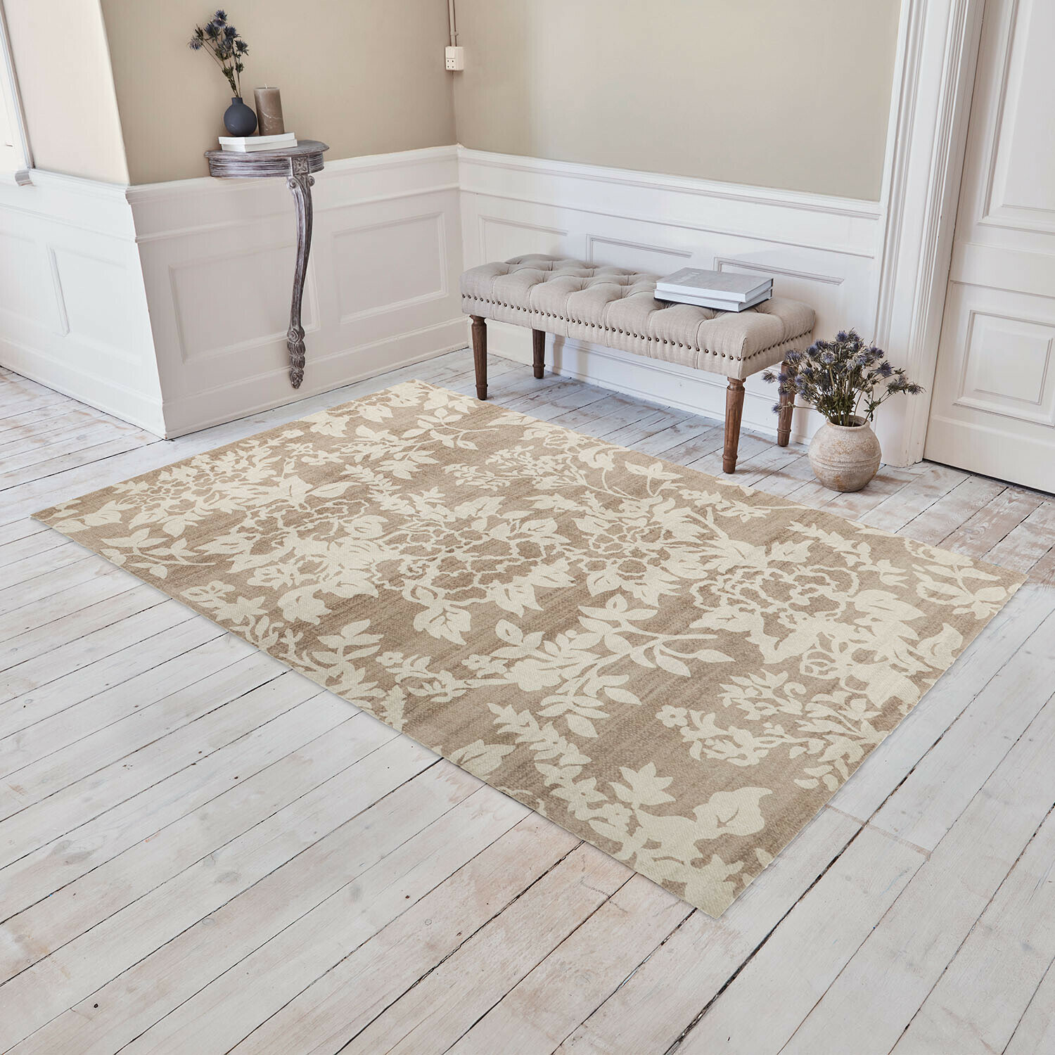 Tappeto Casamira Tappeto beige con motivo floreale su pavimento in legno chiaro in interno elegante