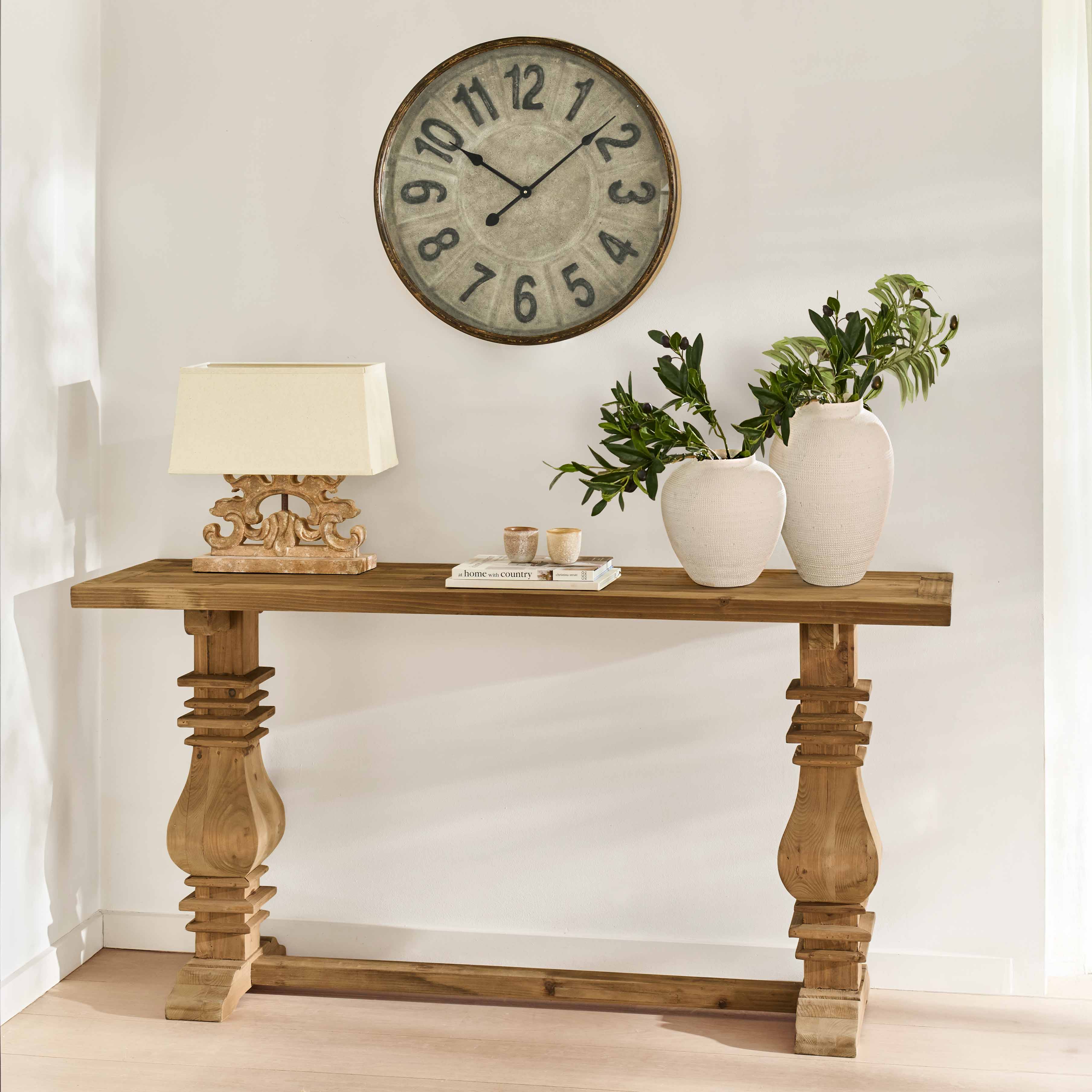 Consolle in legno massiccio con gambe decorate, vasi bianchi in ceramica e lampada su sfondo chiaro