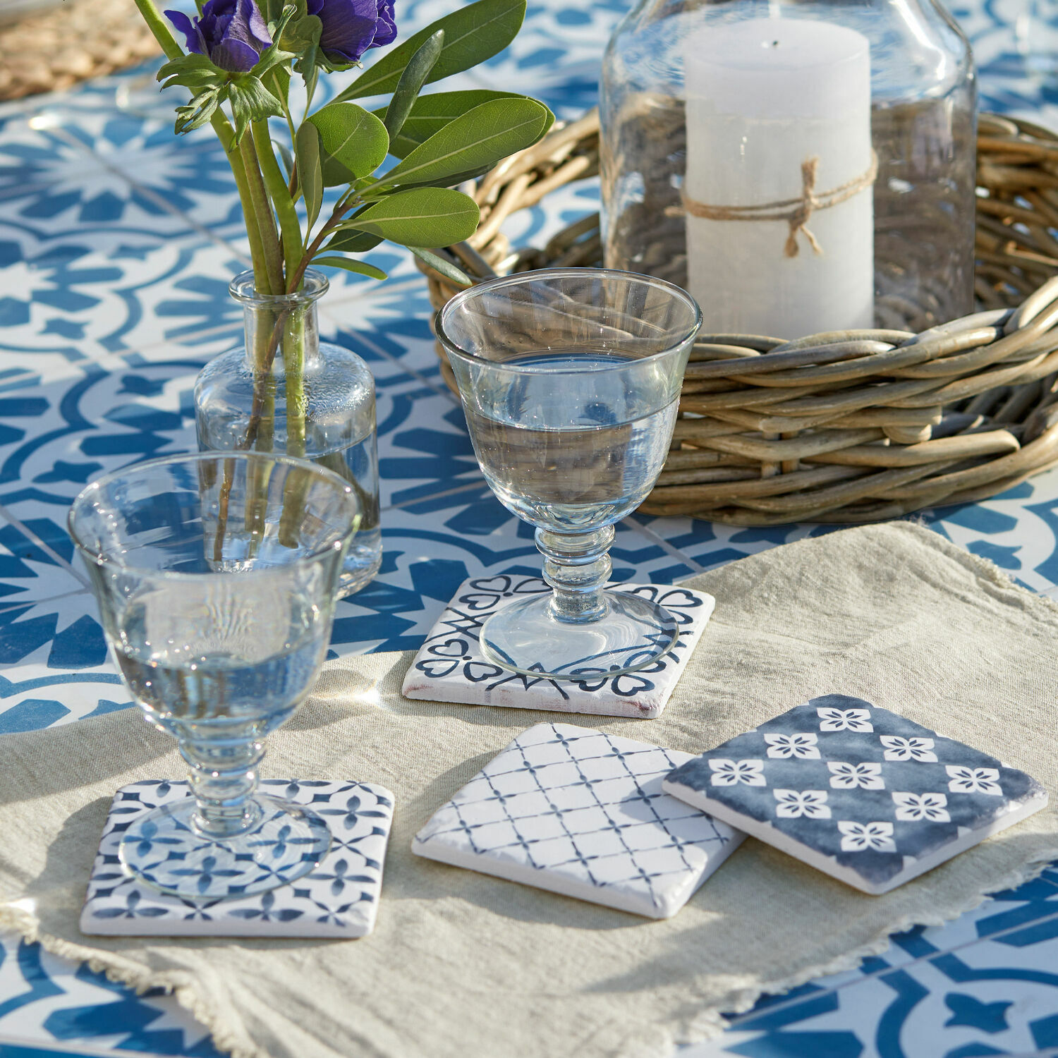 Set di 4 sottobicchieri Sliwa Sottobicchieri in ceramica con motivo blu su sfondo chiaro su tavolo con piastrelle blu