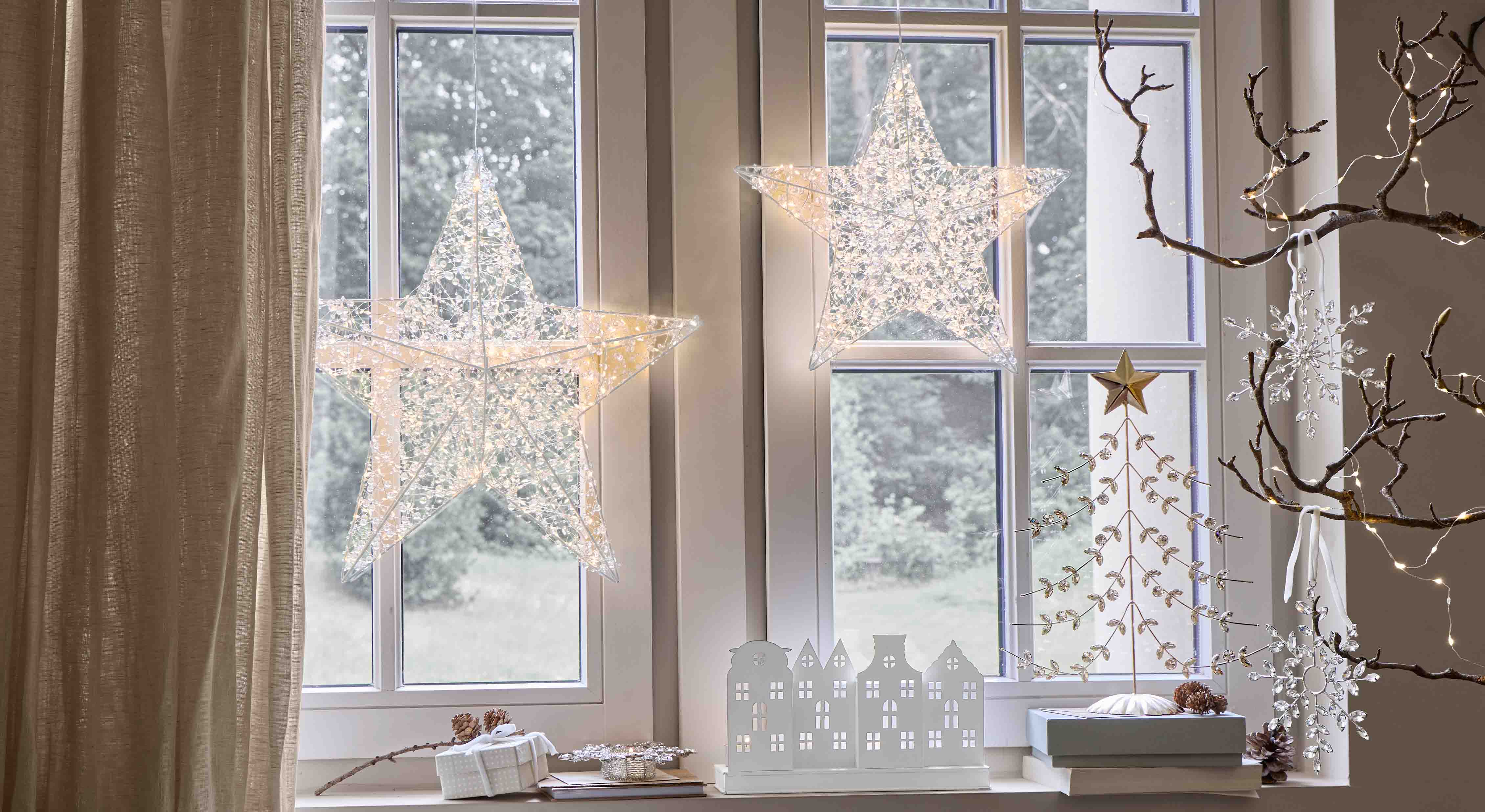 Stelle luminose decorative in materiale trasparente appese alla finestra, illuminazione festiva interna