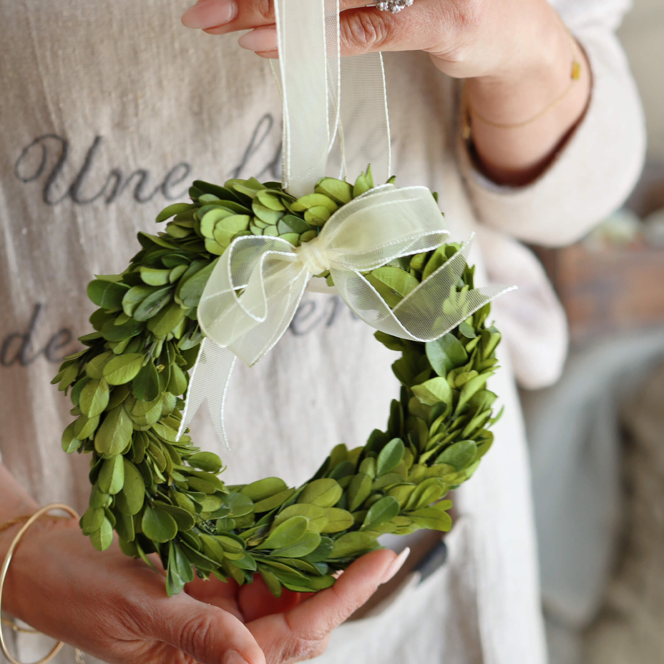 Piccola corona verde di foglie con fiocco bianco, decorazione per casa o porta