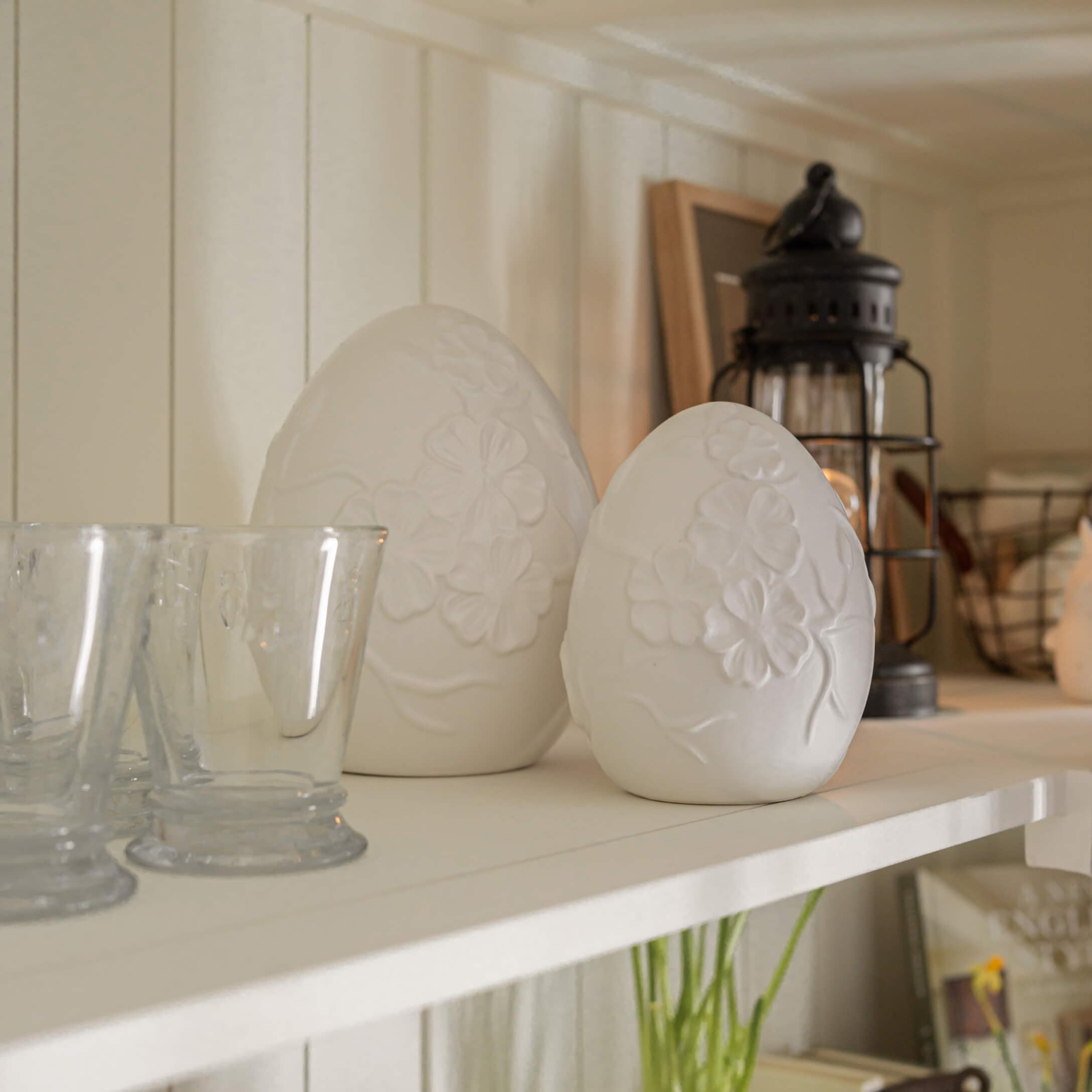 Decorazioni in alabastro bianco a forma di uova con motivo floreale su mensola rustica