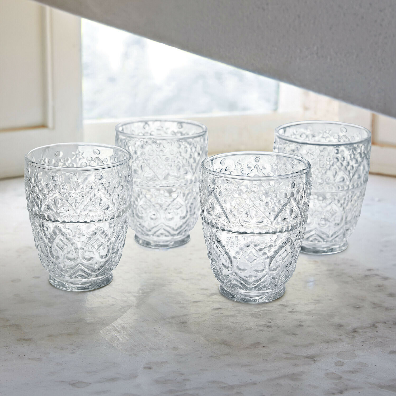 Set di 4 bicchieri Rivoux Bicchieri di vetro con vino rosso e bottiglia su tavolo bianco con lampade decorative in metallo