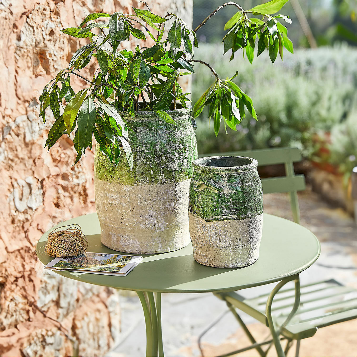 Coppia di vasi Reefton Due vasi in ceramica verde e beige su tavolo da giardino verde con pianta decorativa