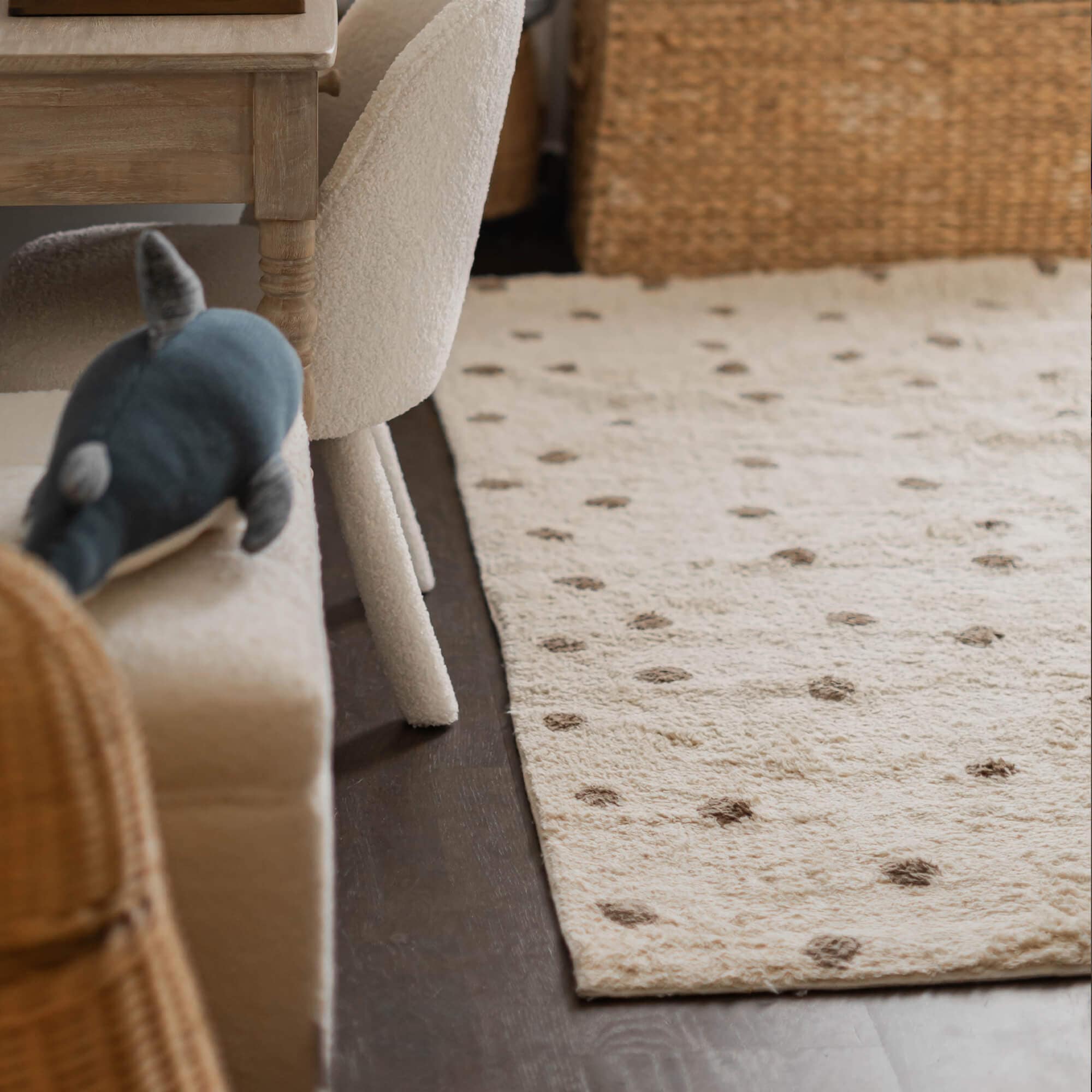 Tappeto beige in materiale morbido con pois marroni su pavimento scuro in soggiorno