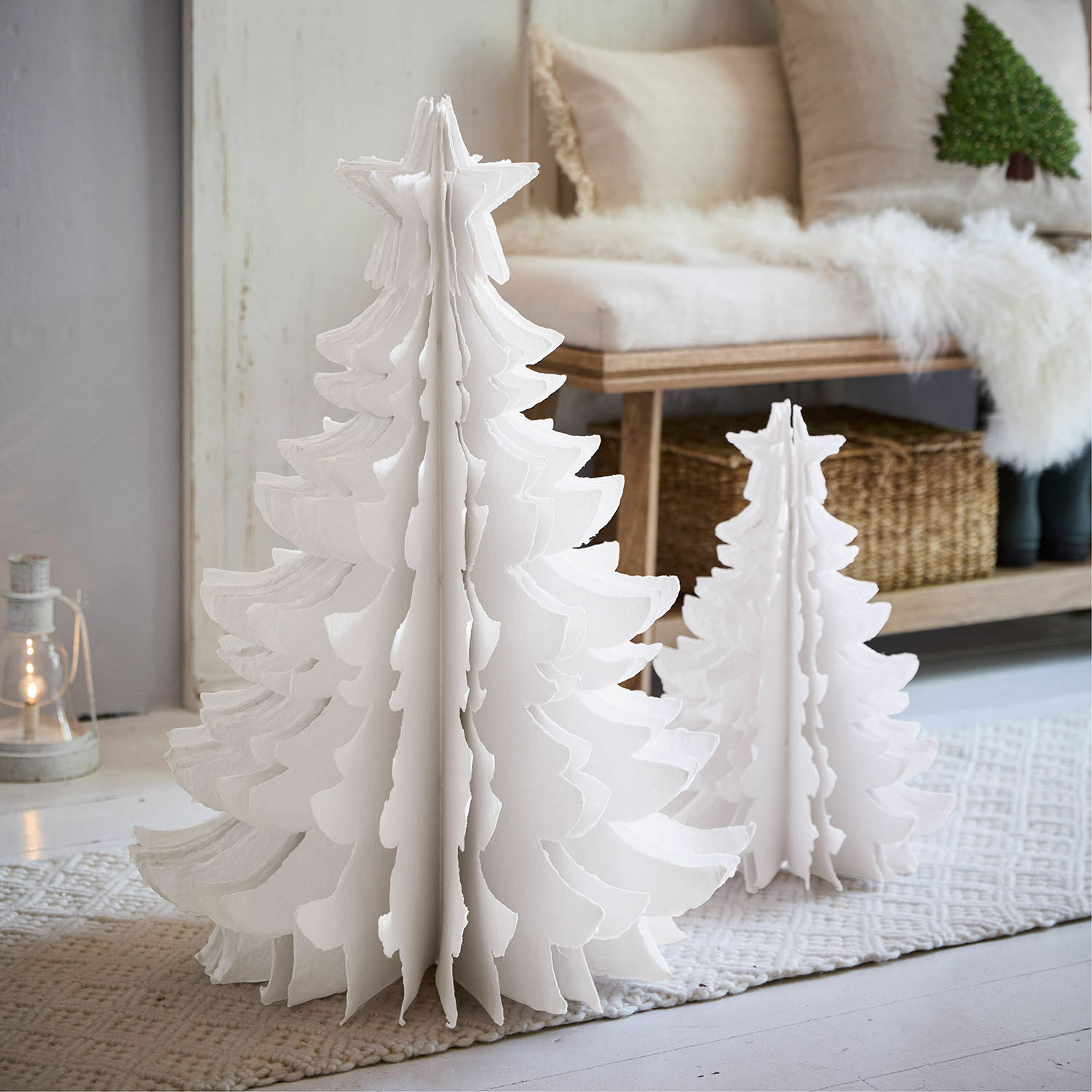 Coppia di alberelli decorativi Amuré Due alberi di Natale decorativi in carta bianca di diverse dimensioni su tappeto in ambiente luminoso